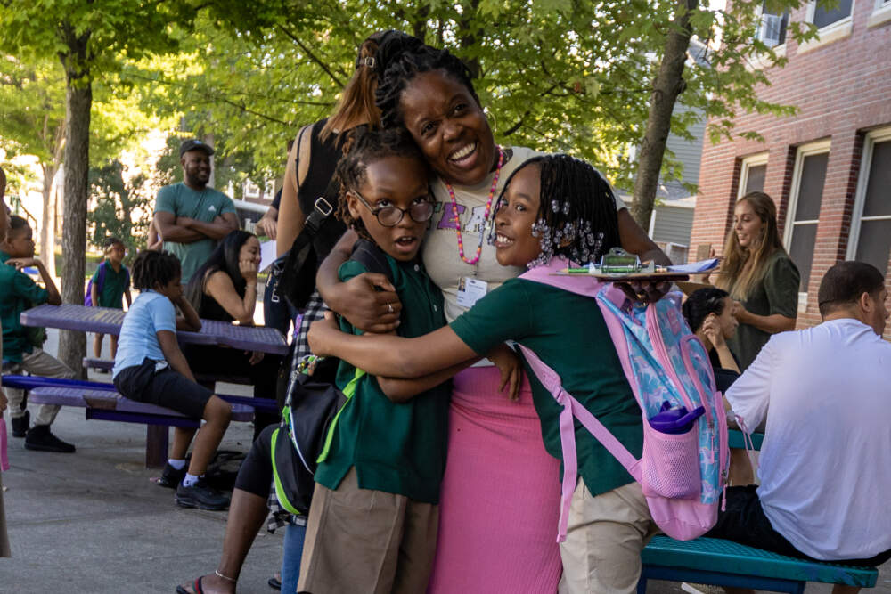 A teacher greets her students at PA Shaw Elementary in Dorchester. (Jesse Costa/WBUR)