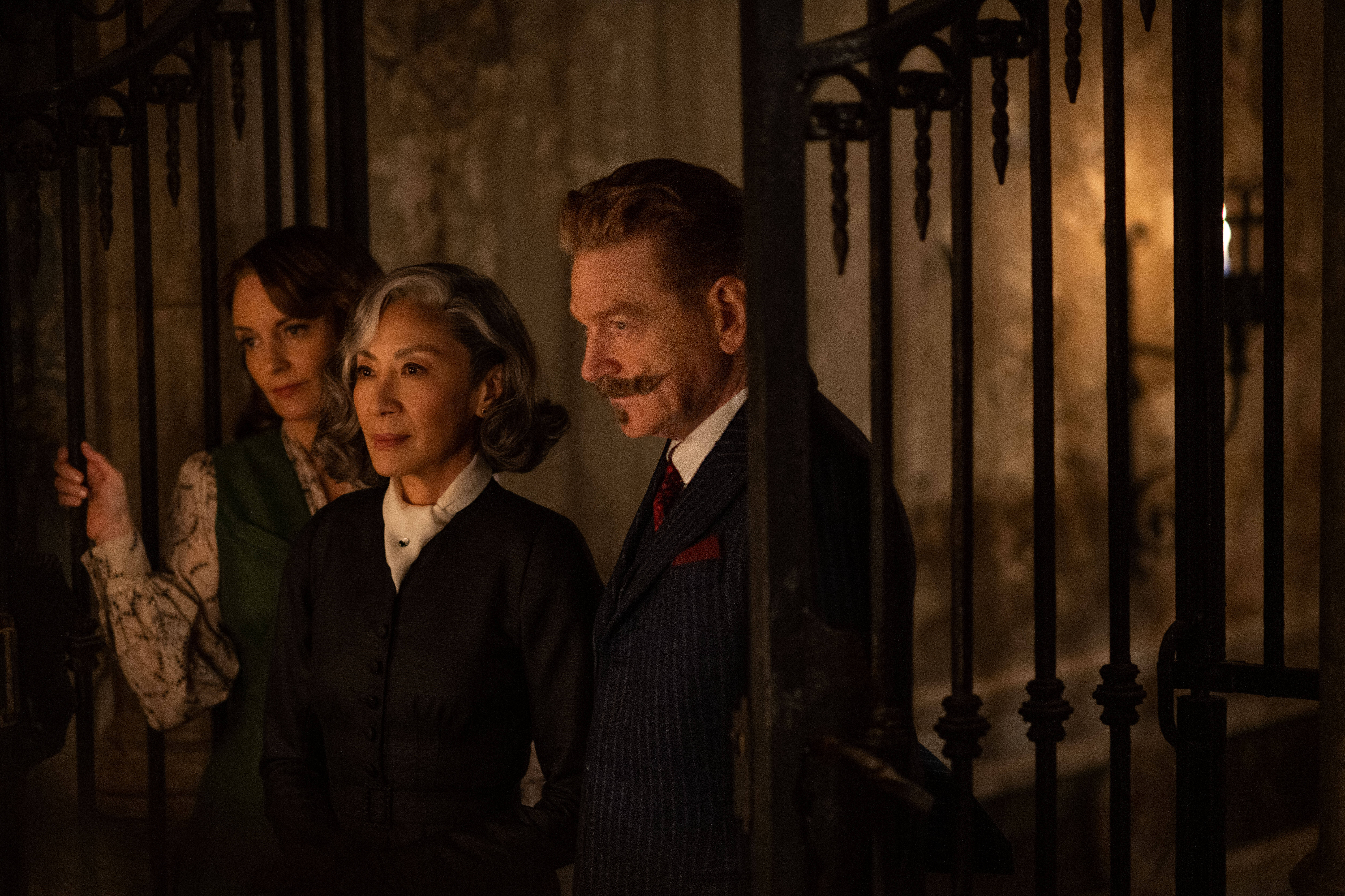 Tina Fey as Ariadne Oliver, Michelle Yeoh as Mrs. Reynolds and Kenneth Branagh as Hercule Poirot in 20th Century Studios' "A Haunting in Venice." (Courtesy 20th Century Studios; photo by Rob Youngson)
