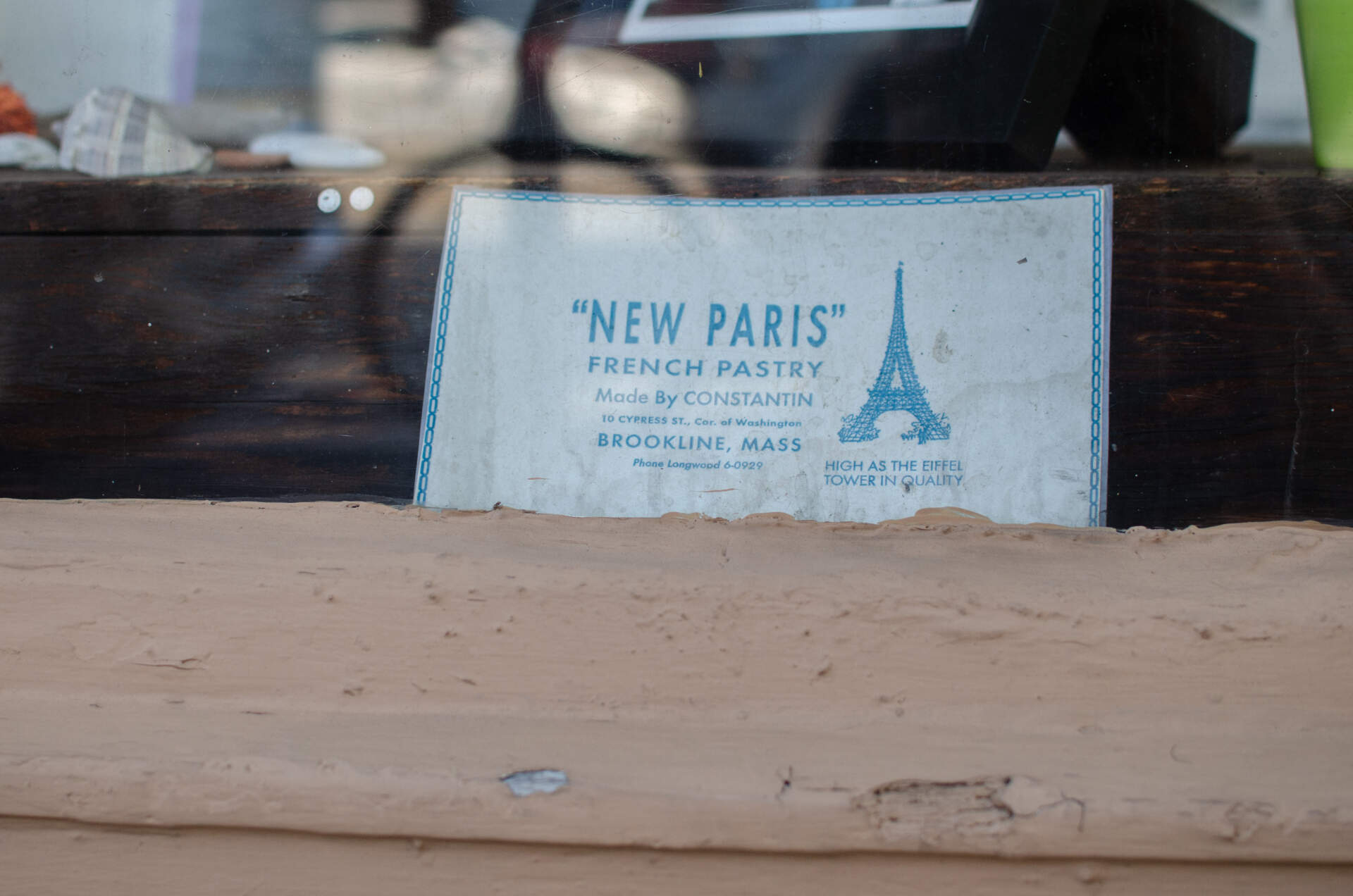 The New Paris Bakery window features a sign from years ago. (Sharon Brody/WBUR)