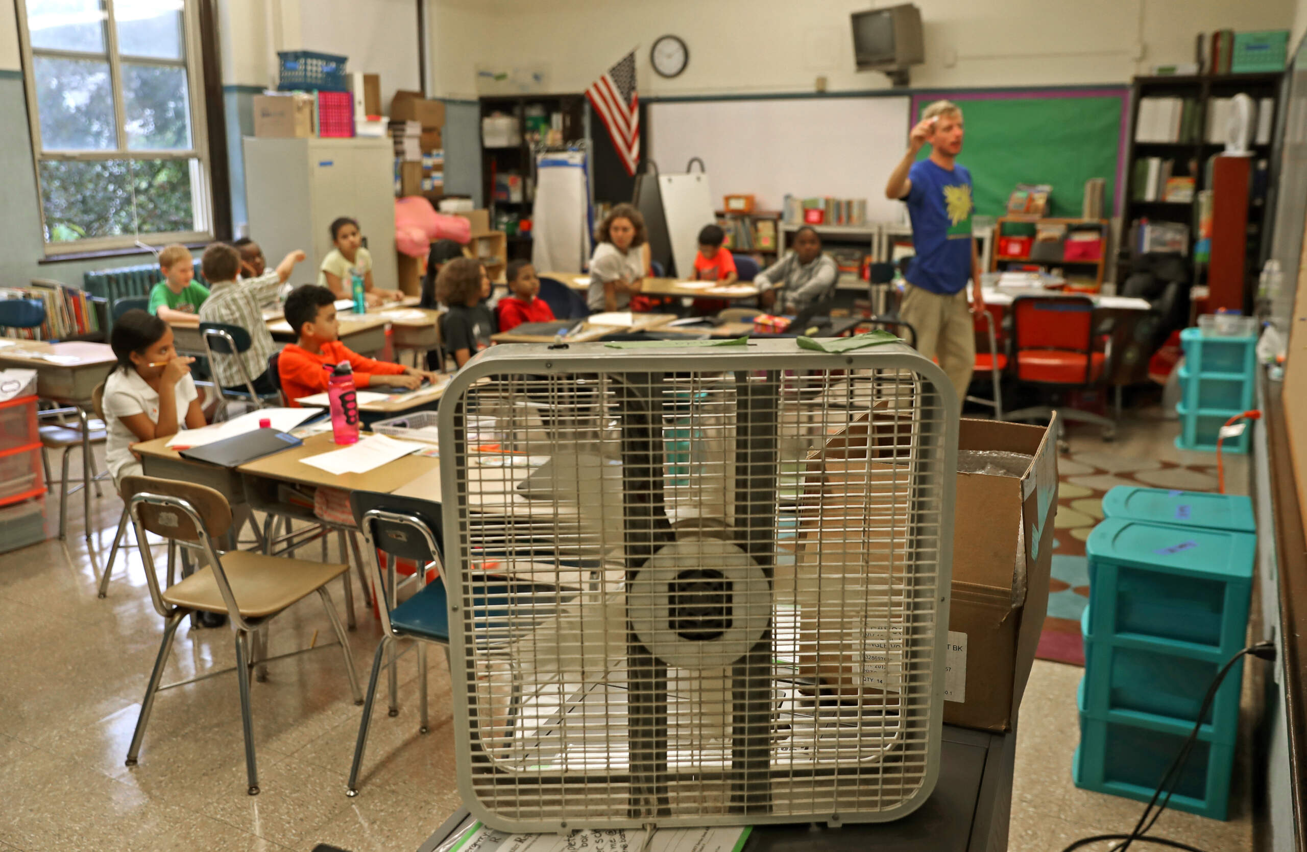 Teacher John Barry uses a fan to cool off his fourth grade classroom at the Mary Curley K-8 school in Jamaica Plain on the first day of school in 2016. (David L. Ryan/The Boston Globe via Getty Images)