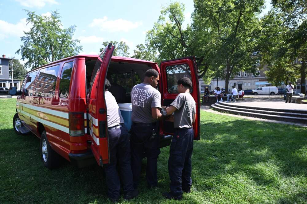 In Hartford, Connecticut, fire department cadets hand out water at Barnard Park during the hottest time of day on September 7, 2023. Drinking water is one of the best ways to protect yourself during extreme heat. (Dave Wurtzel/Connecticut Public)