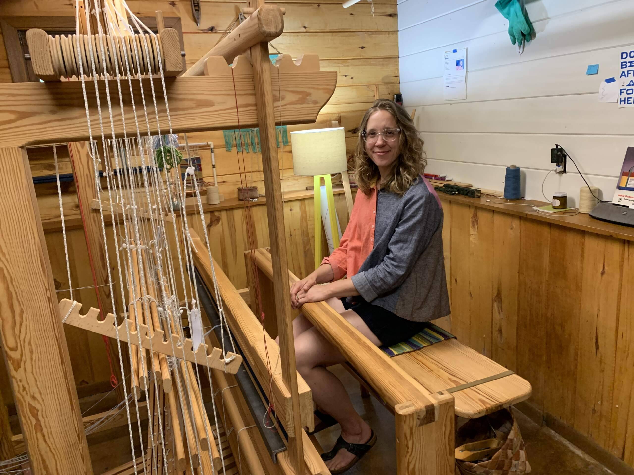 Weaver Christine Novotny sits at the loom in her workshop. (Jon Kalish)