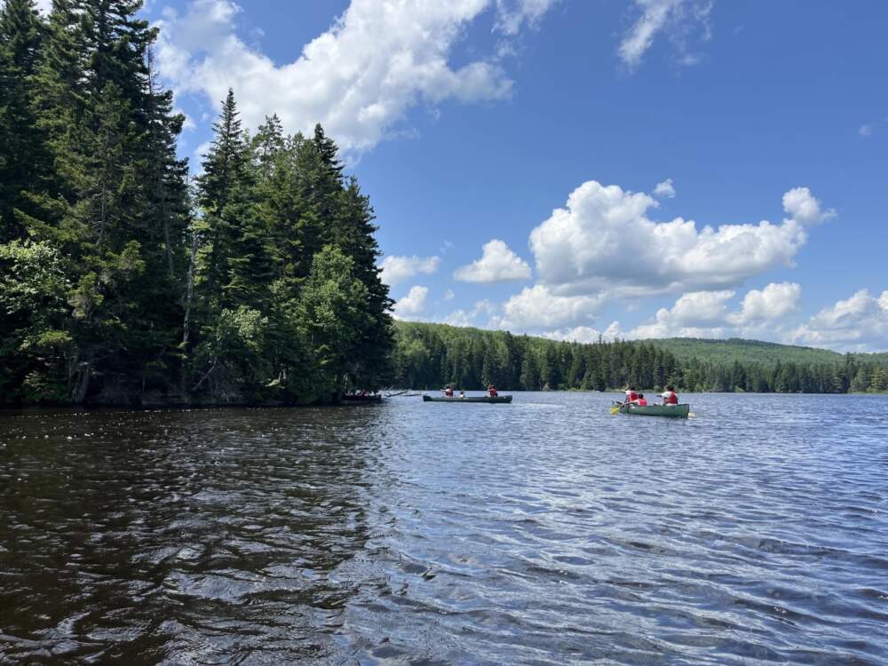 Campers paddle their canoes toward a campsite on the Cupsuptic River near Rangeley this summer. Given the program's success this summer, organizer Moon Machar is extending it into the fall and winter. (Esta Pratt-Kielley/Maine Public)