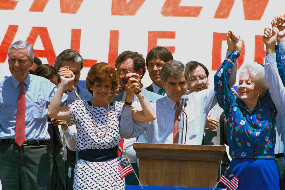 Democratic presidential nominee Michael Dukakis joins hands with his wife Kitty, left, and Ann Richards, Texas state treasurer, during a rally in McAllen, Texas, on July 22, 1988. It was their first appearance since the Democratic Convention in Atlanta. Vice presidential nominee Lloyd Bentsen joins in at far left. (ELG/AP)