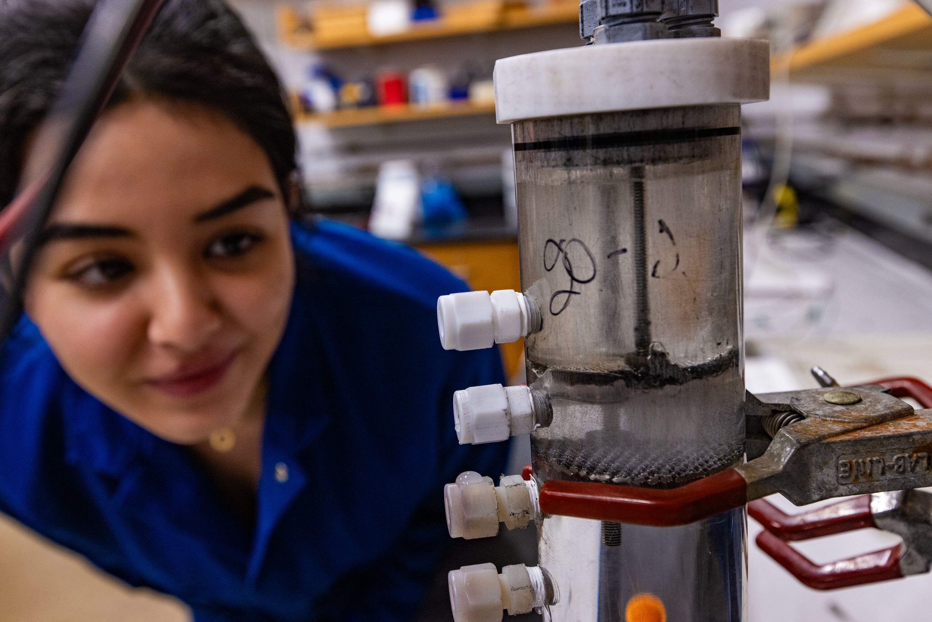 Stephanie Sarrouf, a PhD student at Northeastern University working in the lab of Akram N. Alshawabkeh, demonstrates a prototype "flow reactor," which can be used to remove pollutants from water. Students working in Alshawabkeh's lab are hoping to modify this technology for use in ocean iron enhancement experiments. (Jesse Costa/WBUR)