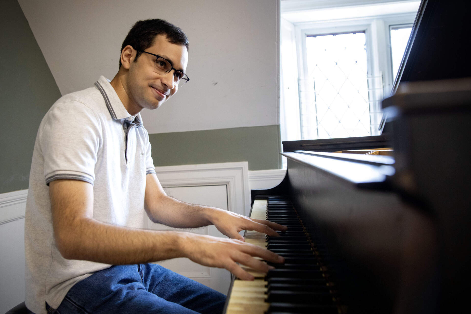 Pianist, composer and conductor Arson Fahim plays a piano at the Longy School of Music in Cambridge. (Robin Lubbock/WBUR)