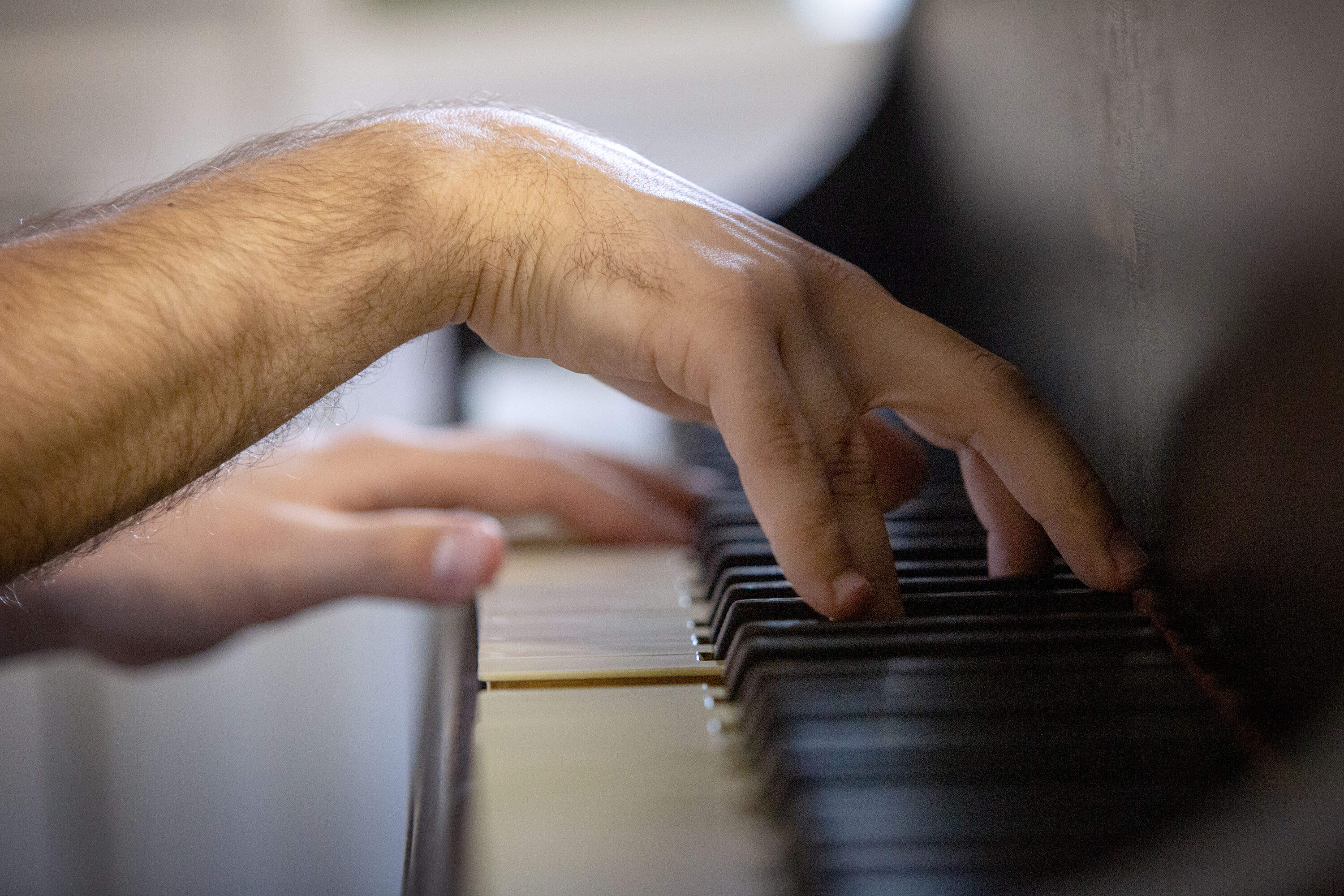 Pianist, composer and conductor Arson Fahim plays a piano at the Longy School of Music in Cambridge. (Robin Lubbock/WBUR)