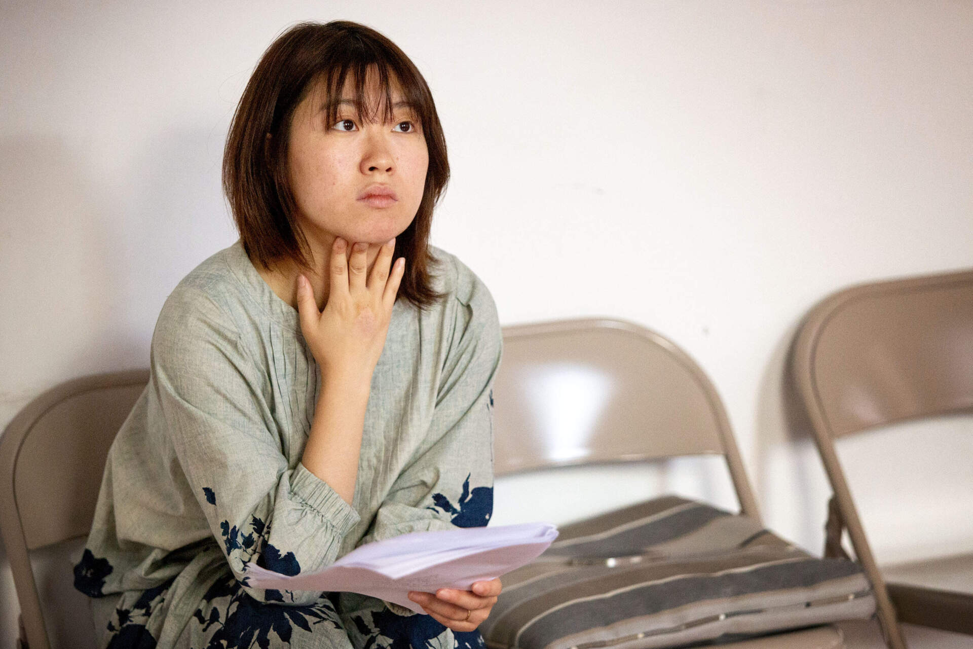 Theater producer and director Alison Qu watches actors in rehearsal at a Boston studio. (Robin Lubbock/WBUR)