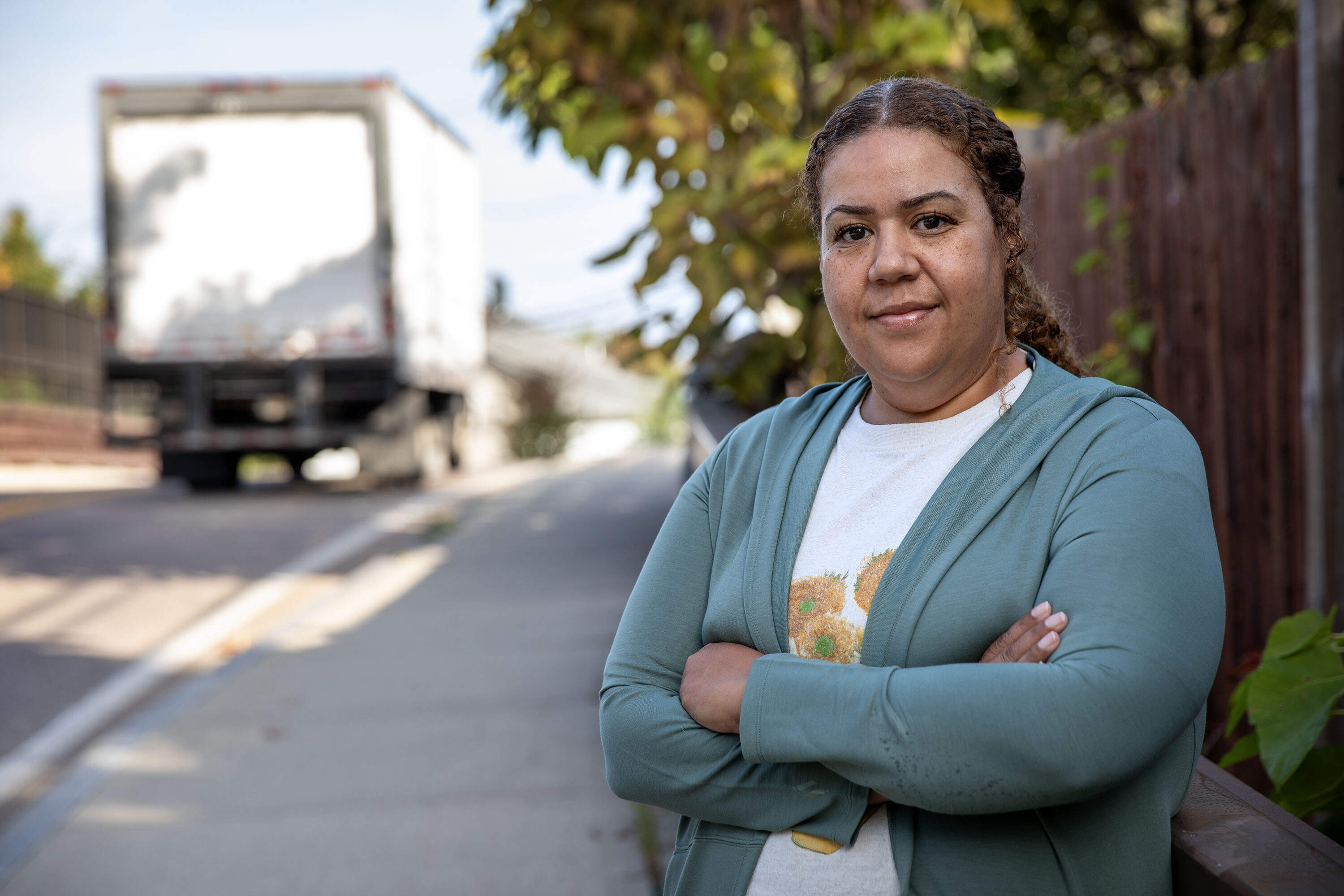 Margie Ann Rosario, of Voices of the Community, stands at a busy section of Fountain Street in Framingham. Students must walk along the sole sidewalk along the road to get to school. (Robin Lubbock/WBUR)