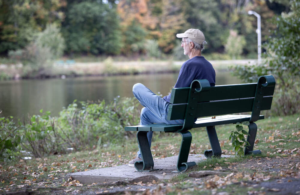 Fred Hewett sits on the bank of Charles River in Herter Park, Boston. (Robin Lubbock/WBUR)
