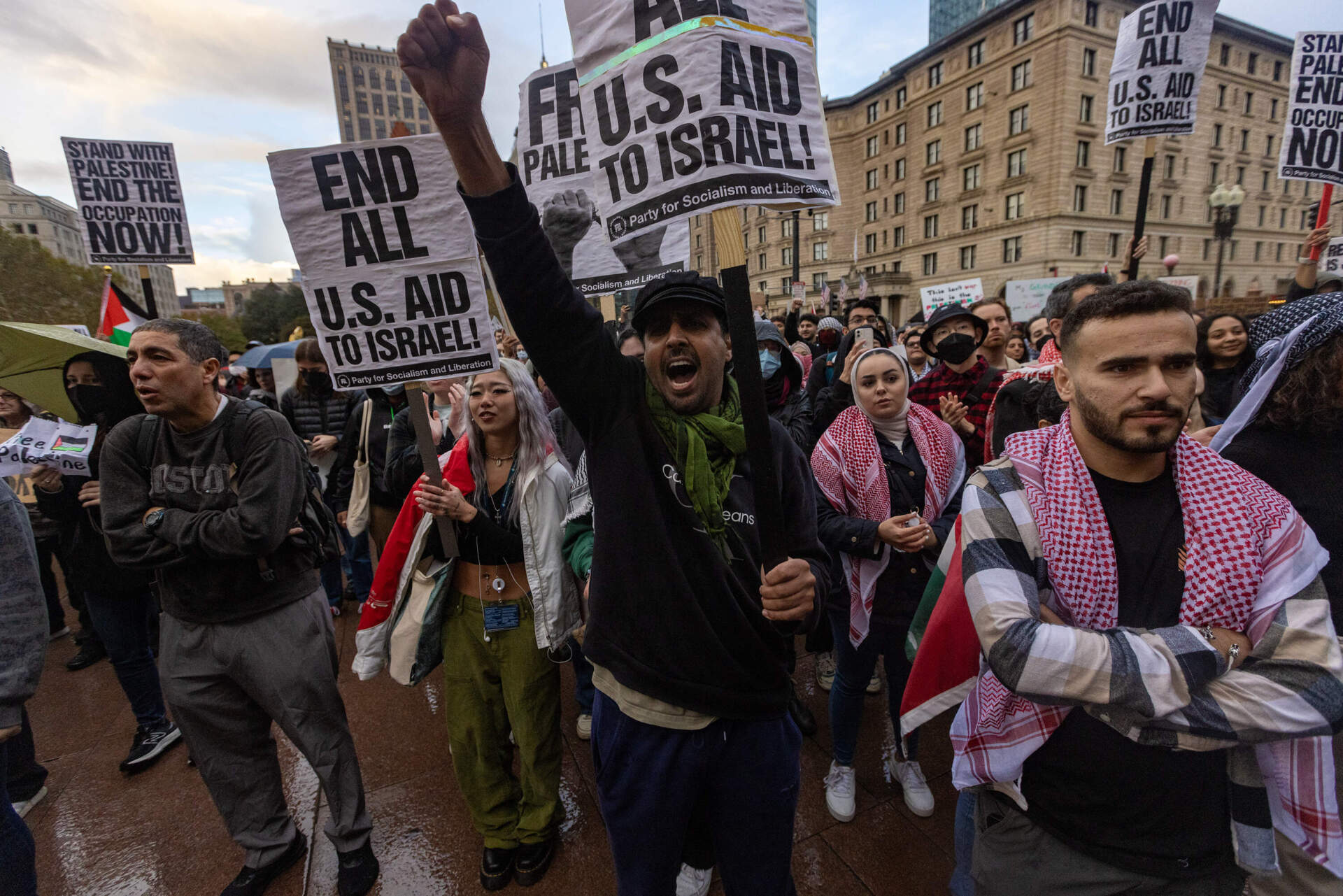 Protesters hold signs that call for an end to U.S. aid to Israel. (Jesse Costa/WBUR)
