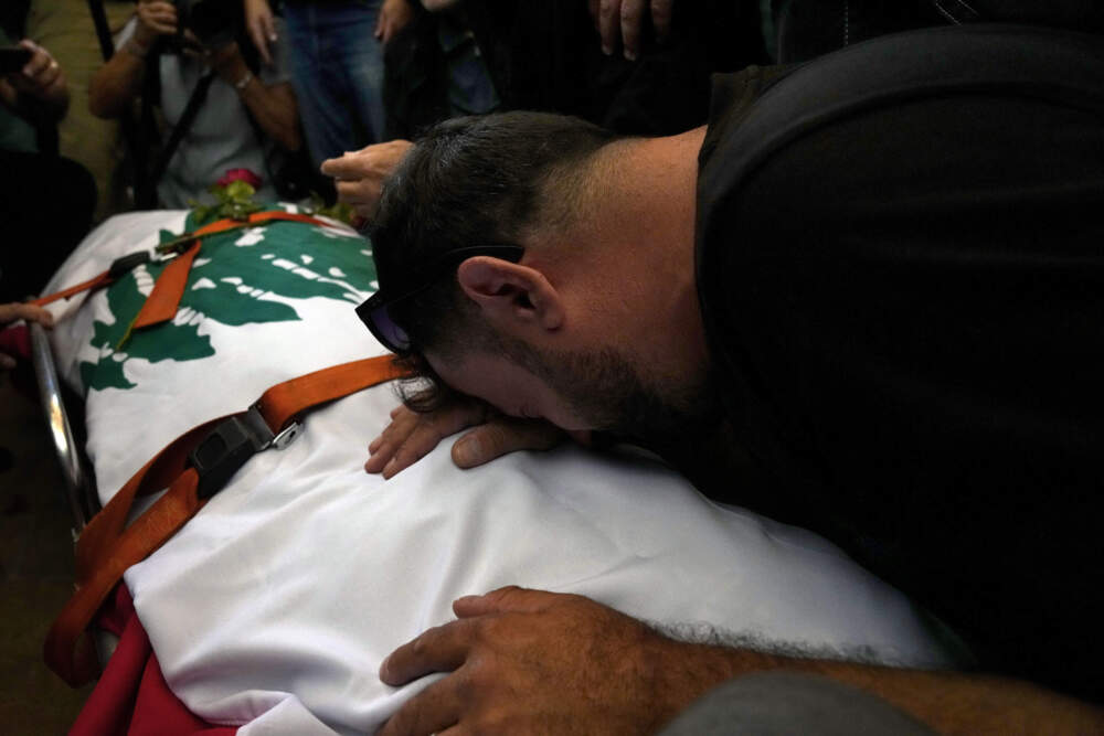 A friend of Reuters videographer Issam Abdallah who was killed by Israeli shelling mourns over his body during his funeral procession in his hometown of Khiam, southern Lebanon, Saturday, Oct. 14, 2023. Abdallah was killed Friday, Oct. 13, when an Israeli shell landed in a gathering of international journalists covering clashes on the border in south Lebanon. Six other journalists were injured in the incident. (Bilal Hussein/AP)