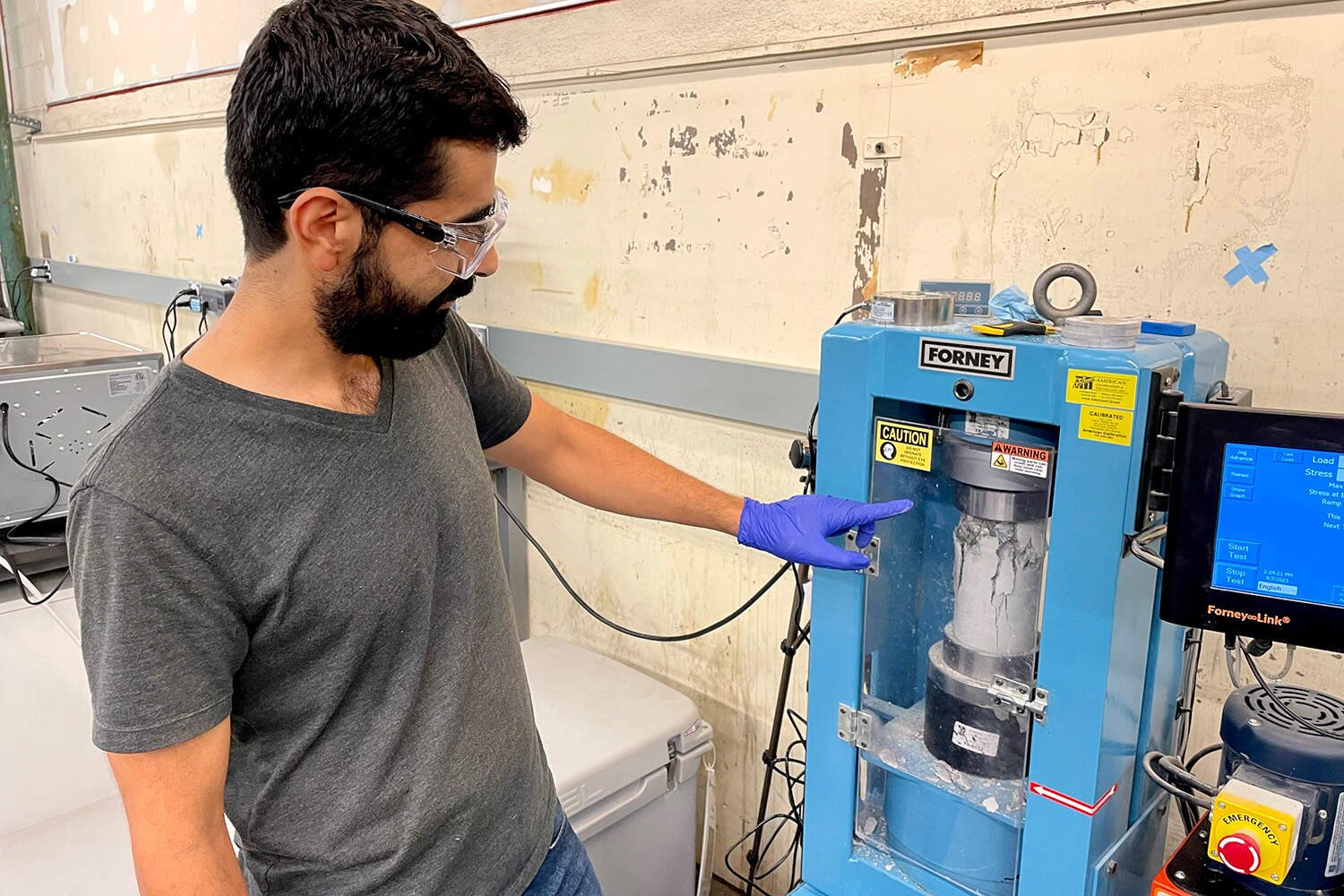 Mehdi Rashidi, Senior Research Scientist at Sublime Systems, conducts a strength test on a concrete column. (Somerville, Mass, 9/7/2023)