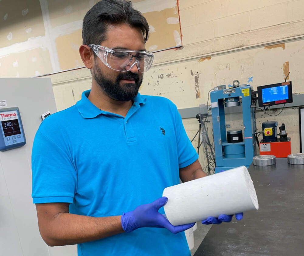 Luis Baquerizo, Head of Product at Sublime Systems, examines a concrete cylinder made with Sublime’s proprietary cement. (Somerville, Mass, 9/7/2023).