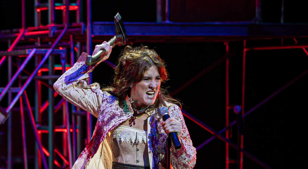 A woman holds an axew in the role of Lizzie Borden for 'Lizzie: The Musical'