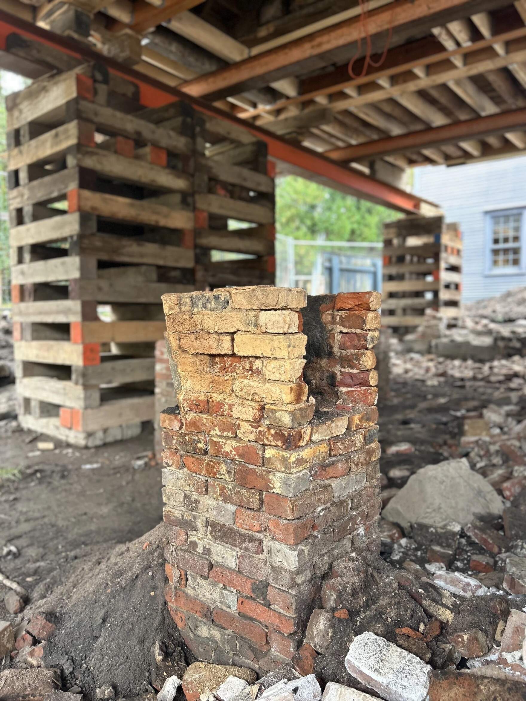 Arron Sturgis, with Preservation Timber Framing, said bricks are like sponges. "When they're completely immersed in water or always soaked, then they begin to decay, just like your kitchen sponge," he said. These bricks, once the base of a chimney, experienced water damage. (Mara Hoplamazian/NHPR)