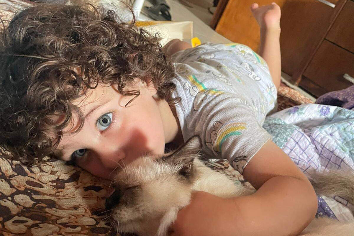 Yousef Okal with a stray cat his family took in to help keep his calm during the explosions in the Gaza Strip, where the Massachusetts family is trapped. (Photo courtesy Abood Okal)