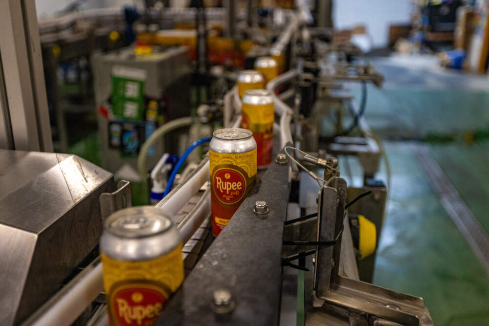 The new Rupee IPA being processed through the canning line at Dorchester Brewing in time for the Diwali celebration. (Jesse Costa/WBUR)