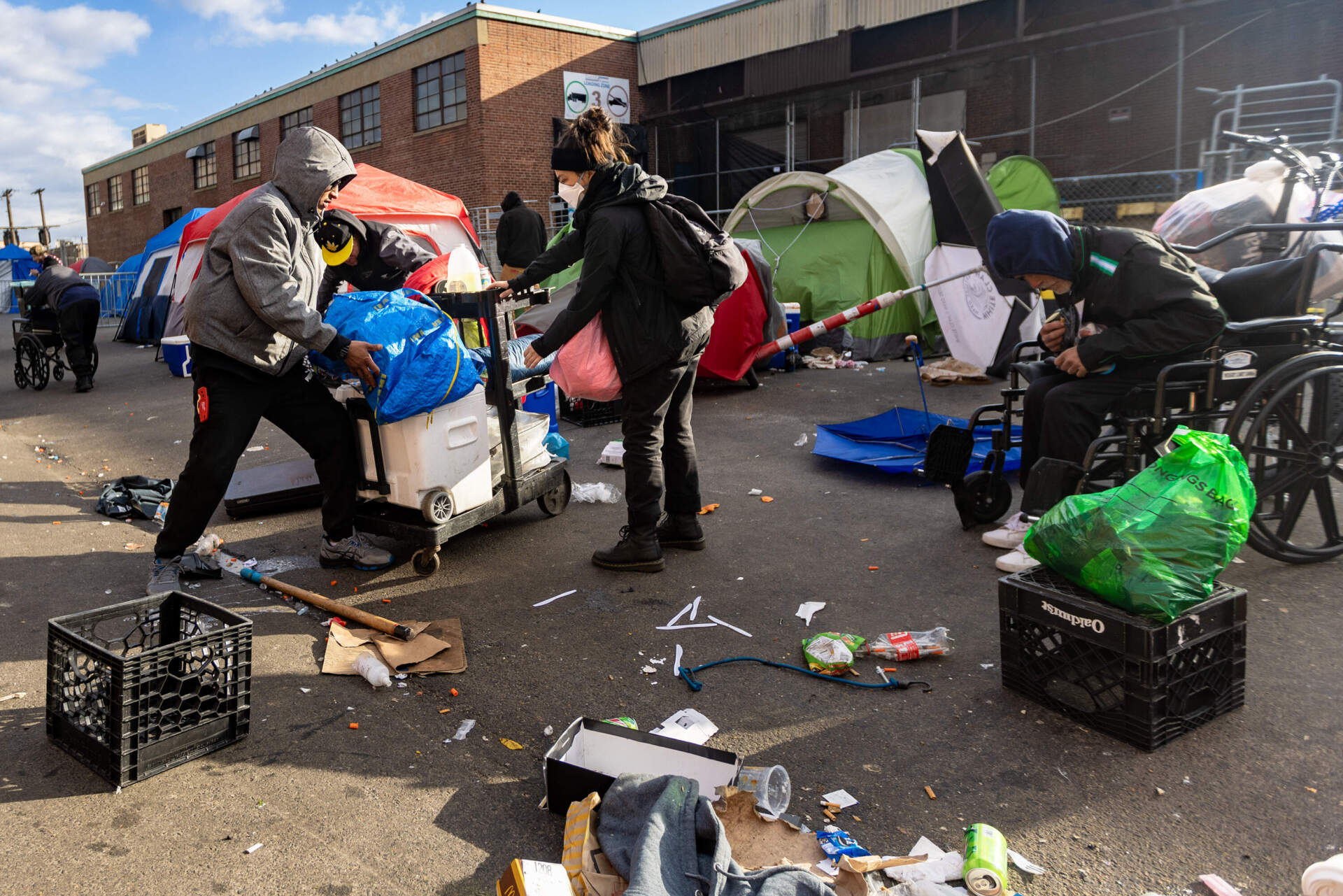 People who were living in the tent encampment on Atkinson Street collect their belongings to prepare to leave the area. (Jesse Costa/WBUR)