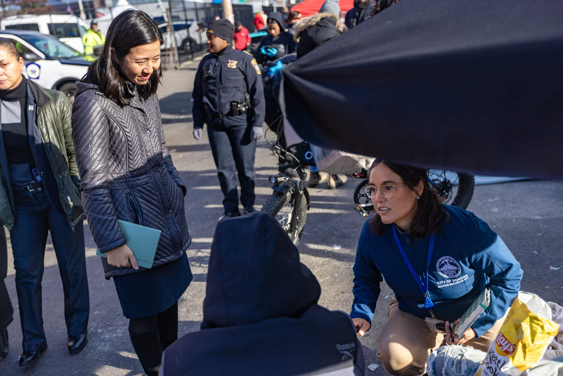 Mayor Michelle Wu and Senior Advisor to the Mayor Tania Del Rio speak with a person who was living in the tent encampment on Atkinson Street. (Jesse Costa/WBUR)