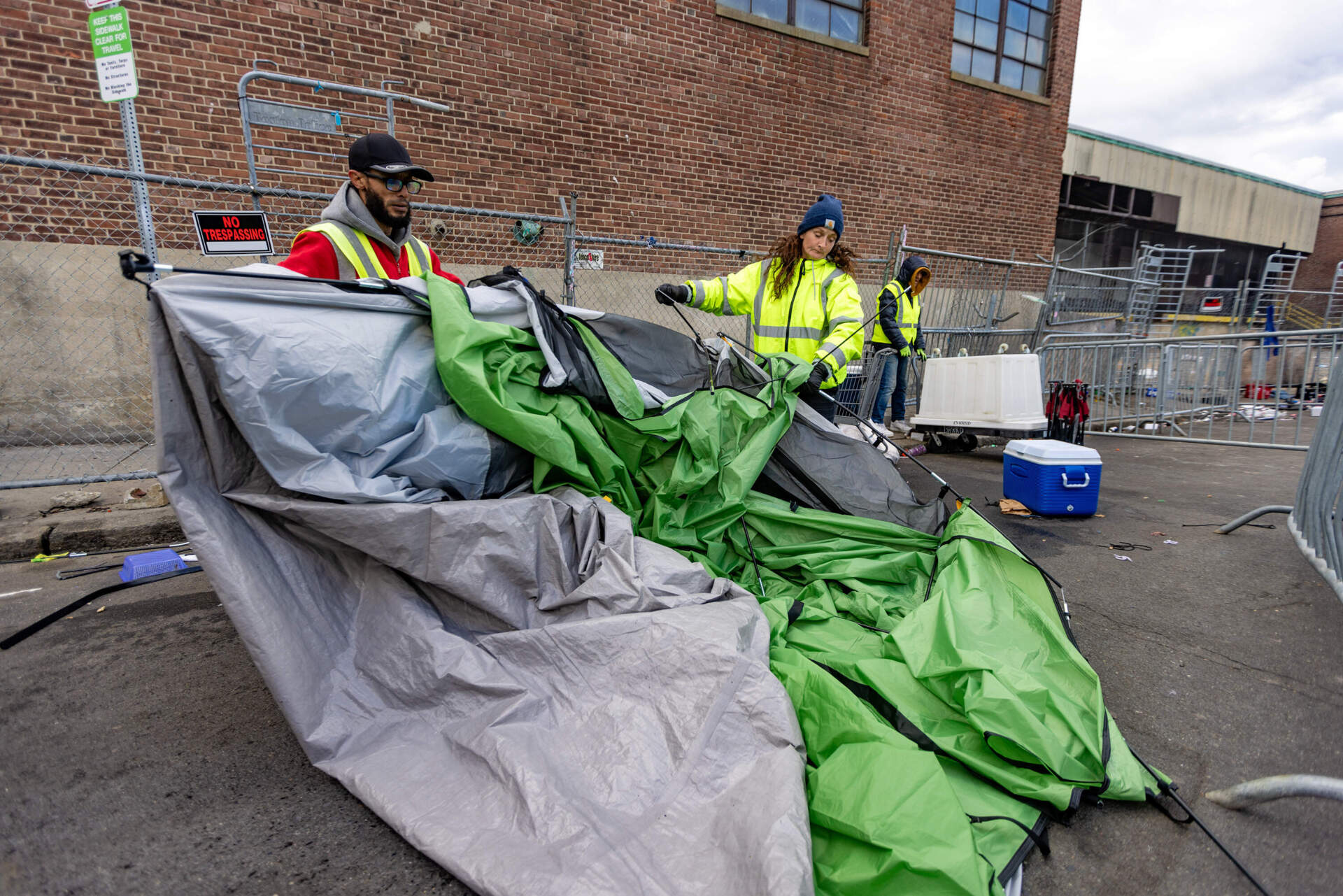 Volunteers from the Newmarket Business Improvement District remove a tent from Atkinson Street. (Jesse Costa/WBUR)
