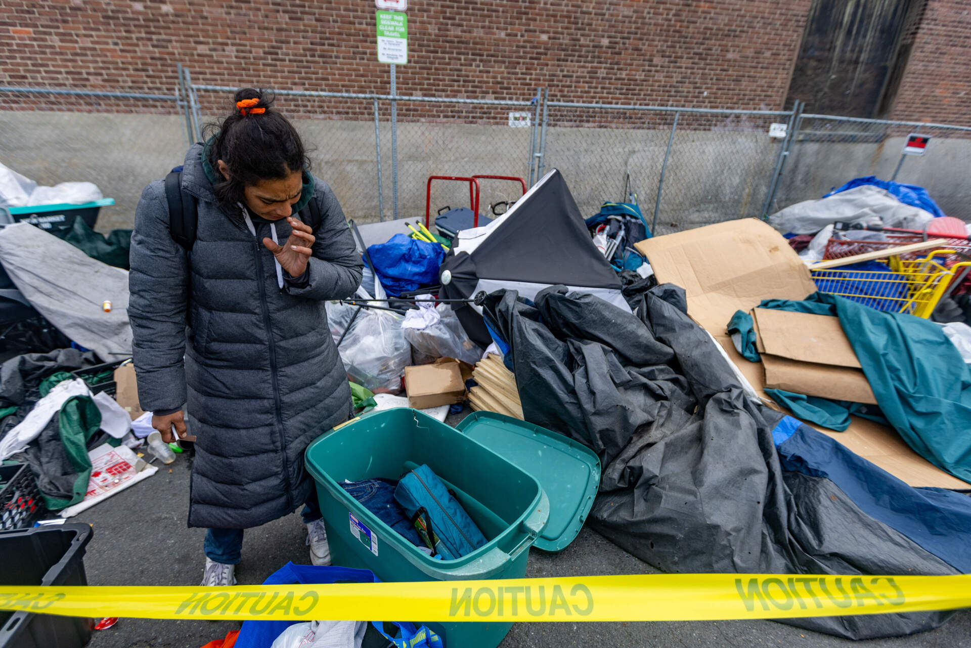 A woman is upset as she tries to sort through the belongings she wants to keep. (Jesse Costa/WBUR)