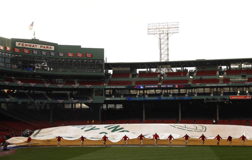 Groundskeepers remove the tarp over the infield at Fenway Park following a rain storm before Game 1 of the World Series baseball game between the Boston Red Sox and Los Angeles Dodgers Tuesday, Oct. 23, 2018, in Boston. (Matt Slocum/AP)