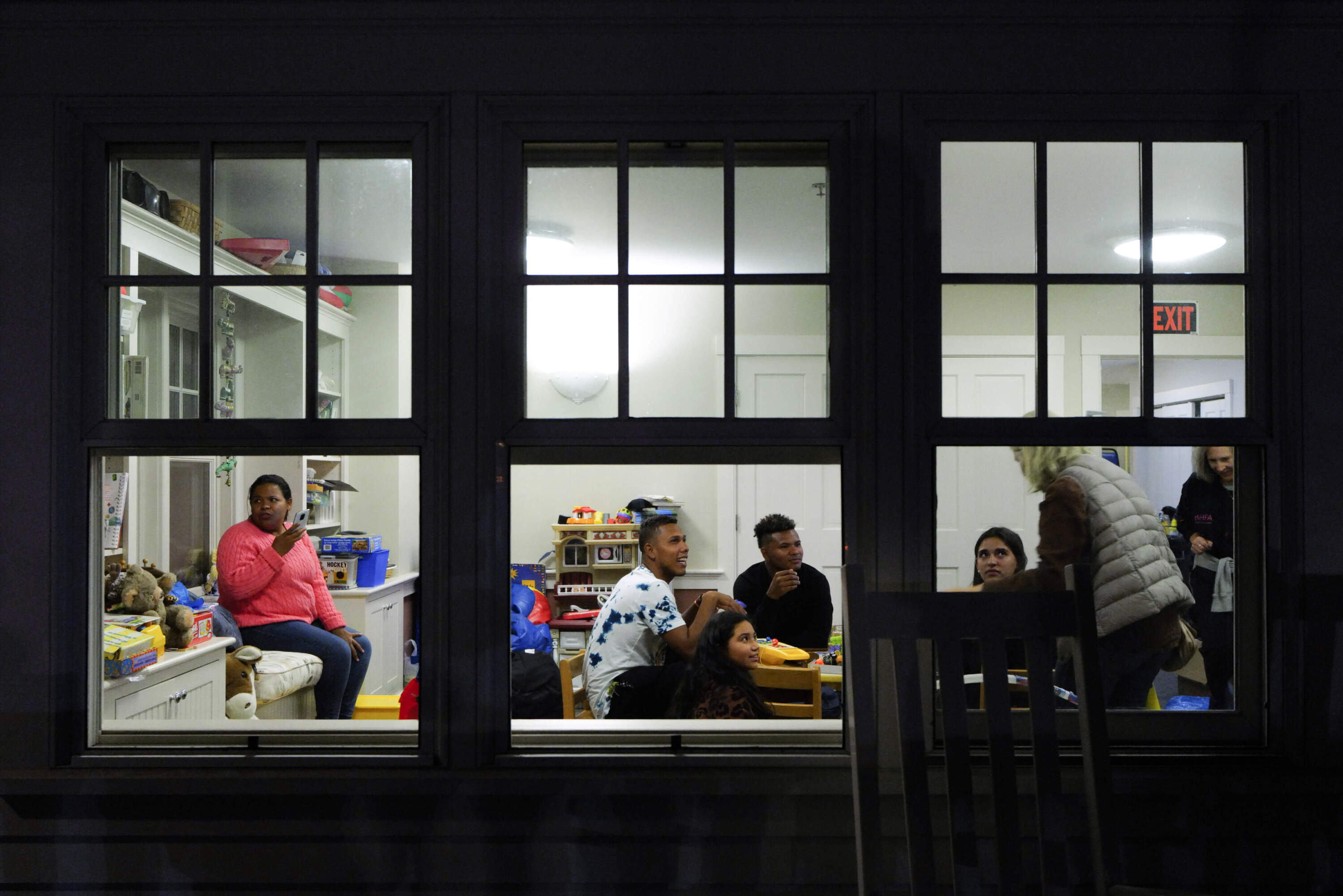 Venezuelan migrants and volunteers gather in St. Andrew's Parish House on Sept. 15, 2022. (Carlin Stiehl For The Boston Globe via Getty Images)