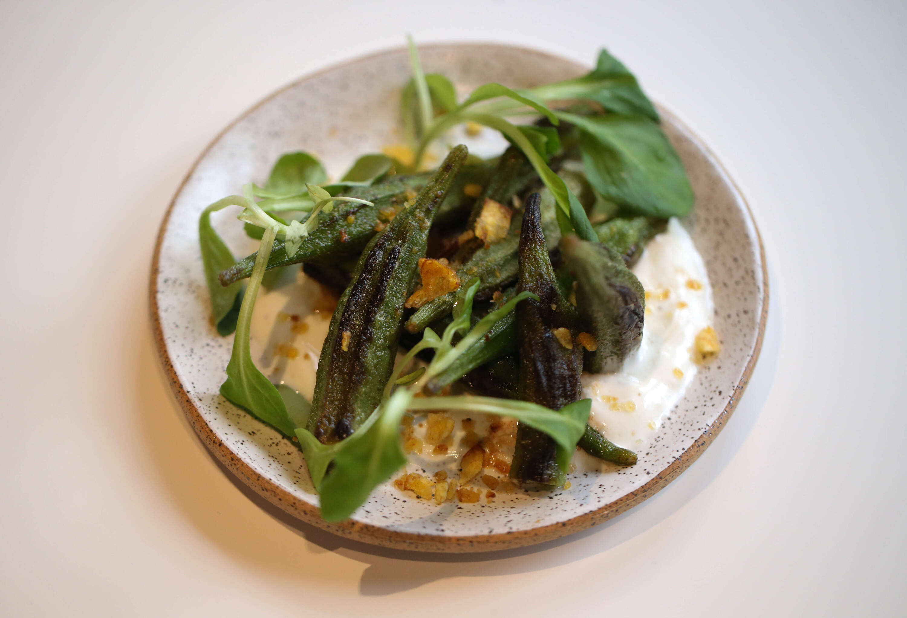 Seared okra with masala spiced yogurt, and plantain crumb at Comfort Kitchen. (Jonathan Wiggs/The Boston Globe via Getty Images)
