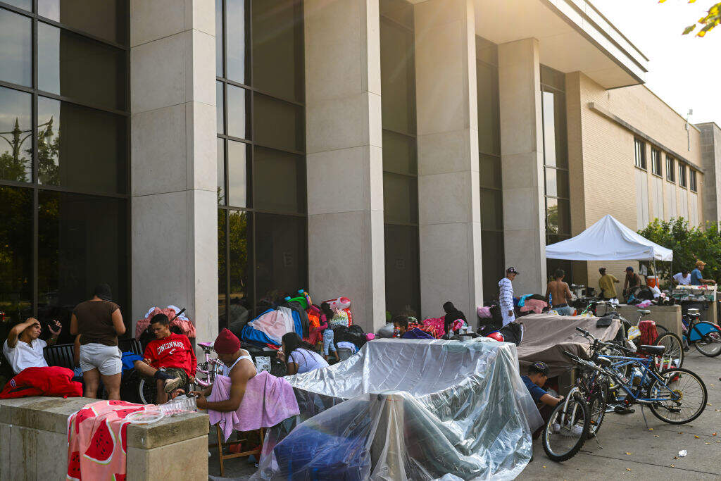 Migrants living at the Chicago Police Department's 15th District are seen outside the station on Sunday, September 10, 2023 in Chicago, Illinois. Since last year, over 14,000 migrants, mostly from Venezuela, have arrived in Chicago by bus from the Texas border. Chicago, which is a sanctuary city has been housing the asylum seekers at police stations, O'Hare International Airport, and city-run shelters. (Photo by Joshua Lott/The Washington Post via Getty Images)