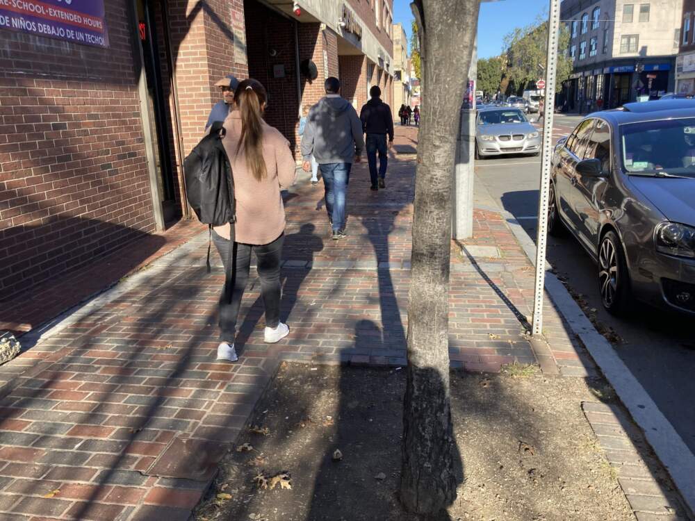 Neghumi walks down the street in Chelsea, where she has received assistance from the nonprofit La Colaborativa. (Gabrielle Emanuel/WBUR)