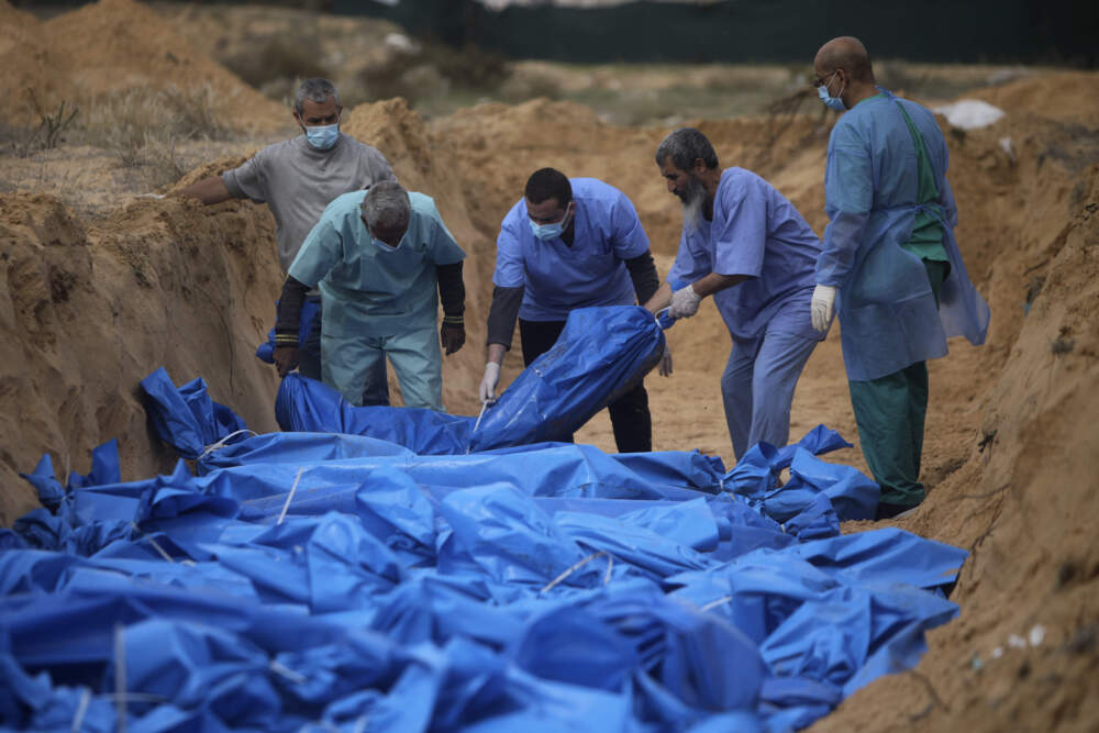 Palestinians bury people killed in the Israeli bombardment who were brought from the Shifa hospital in a mass grave in the town of Khan Younis in southern Gaza on Nov. 22. (Mohammed Dahman/AP)