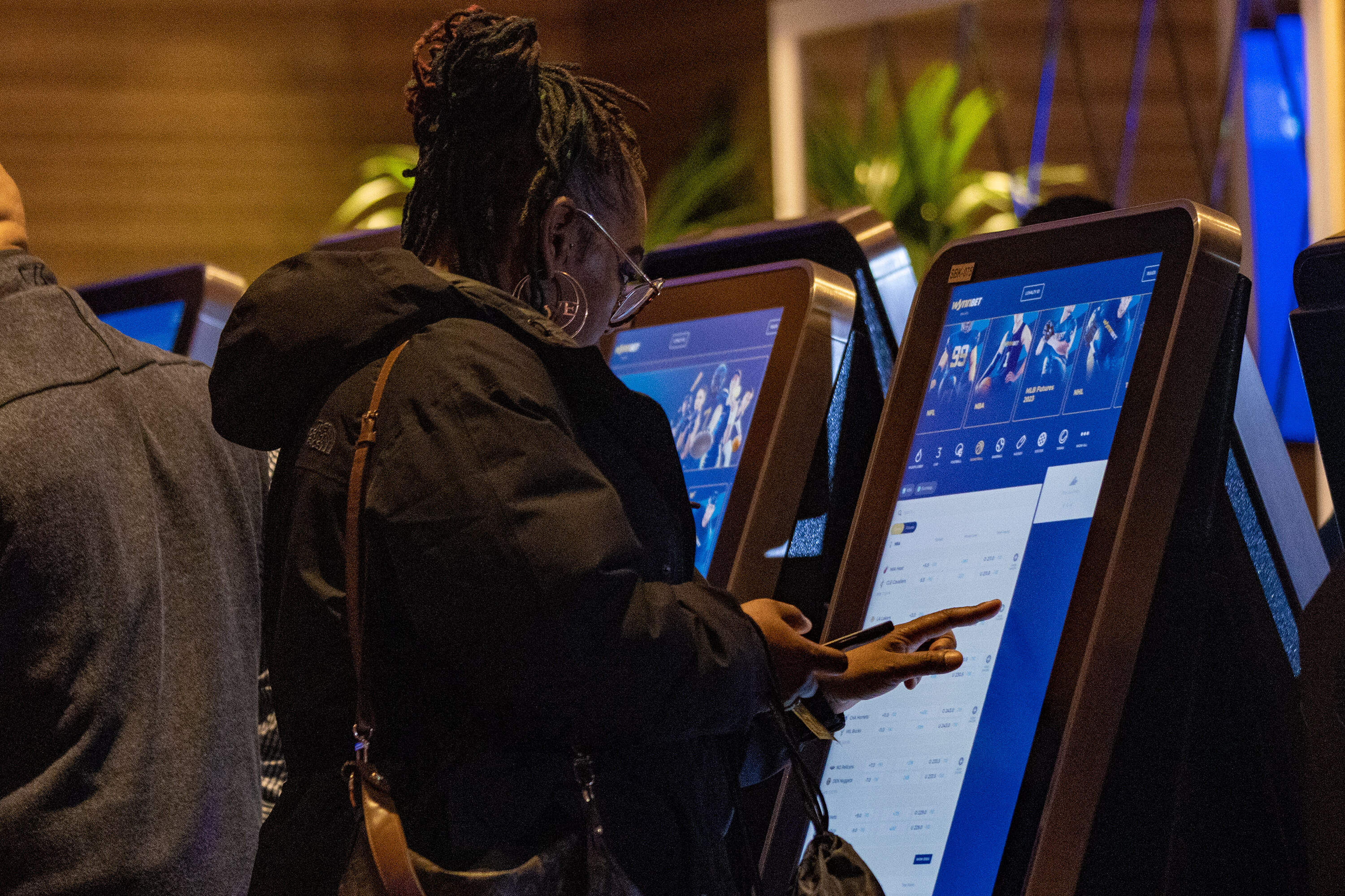 Guests place the first sports bets at the WynnBET Kiosk Room at Encore Boston. (Jesse Costa/WBUR)