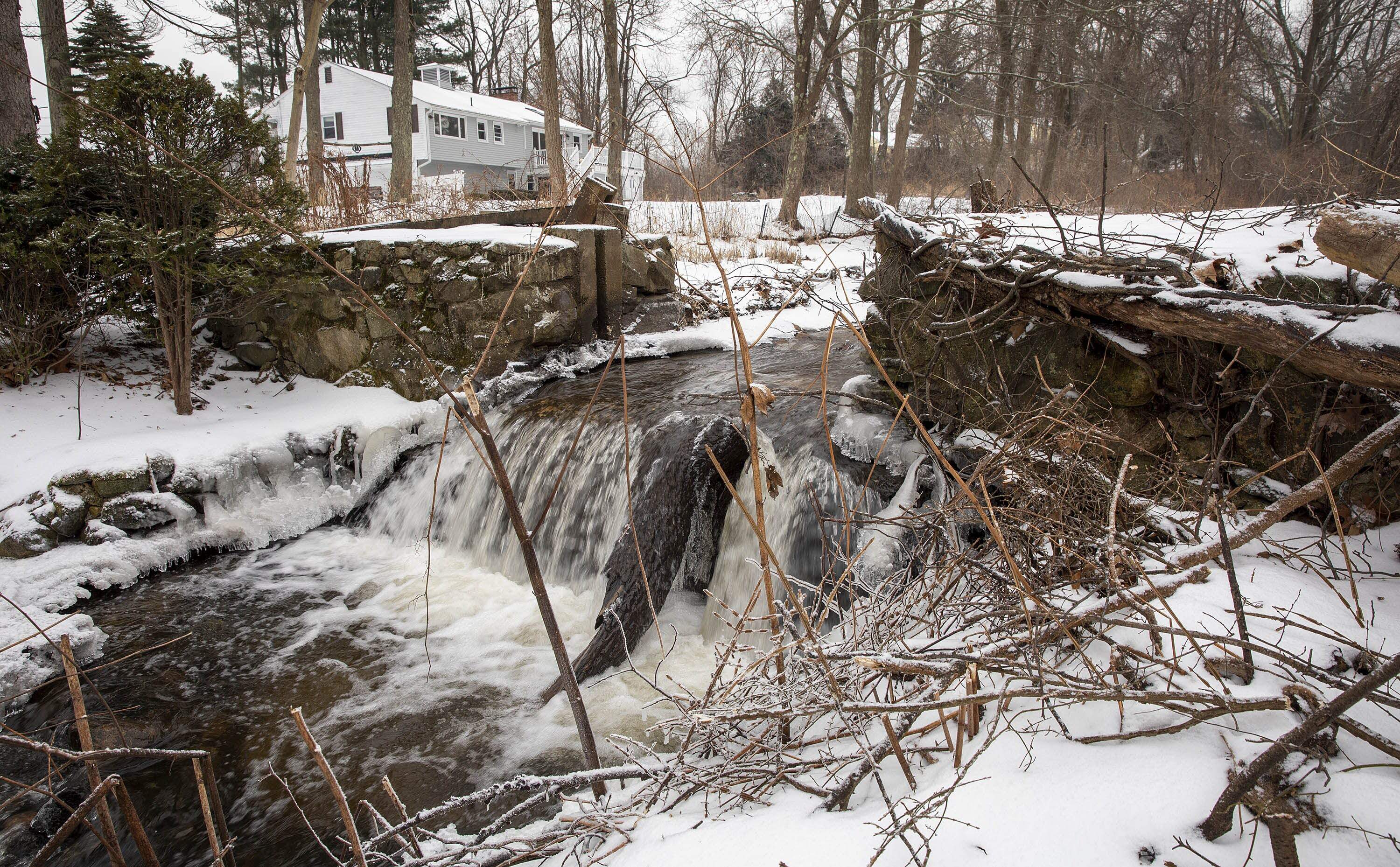 Water flowing through the spillway of the Mill Pond Dam on Traphole Brook in the week before its removal. (Robin Lubbock/WBUR)