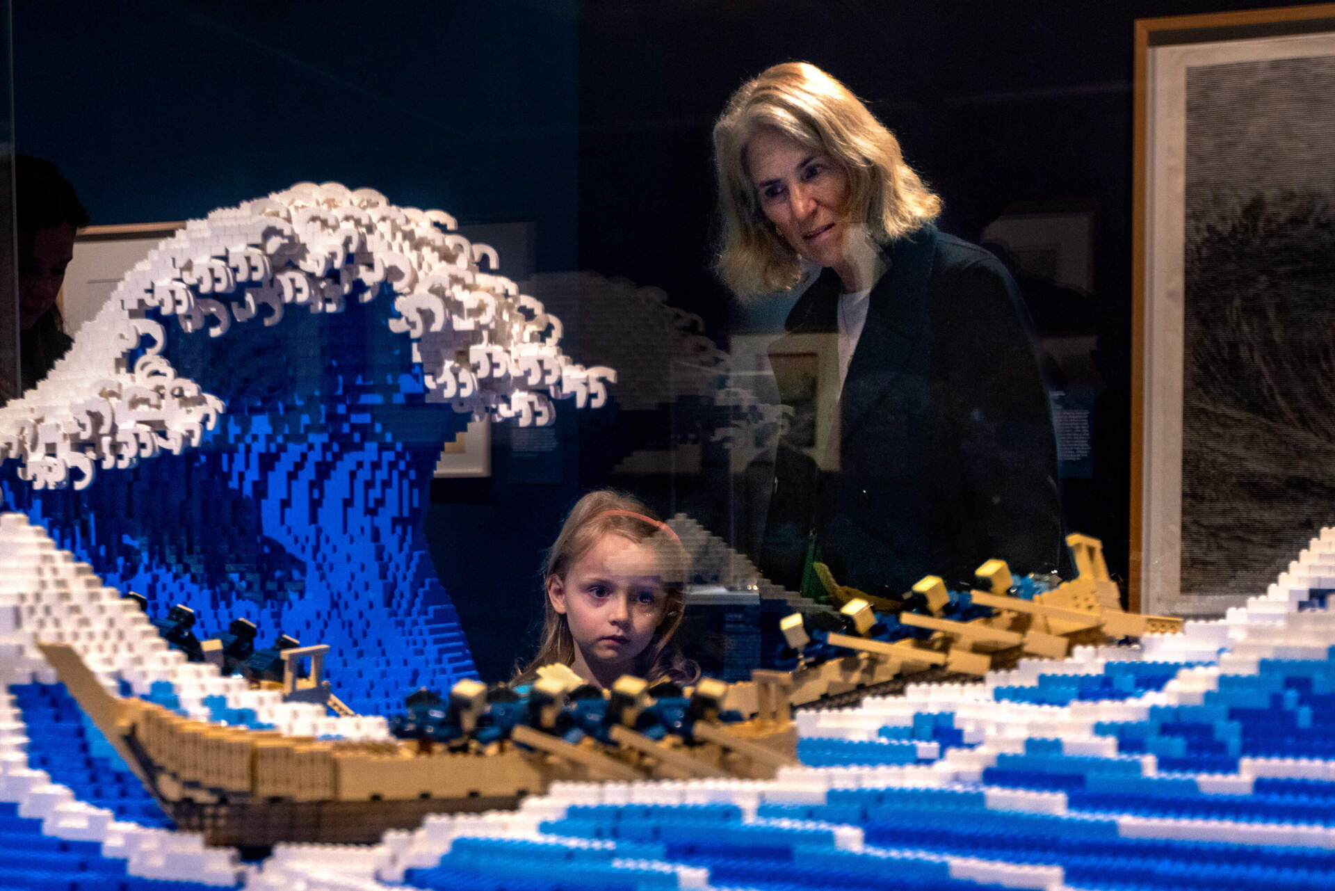 Five-year-old Eleanor Laird and her grandmother Amy Clarkson gaze at “The Great Wave built by Jumpei Mitsui with Lego Blocks” at the Hokusai: Inspiration and Influence show at the Museum of Fine Arts Boston. (Jesse Costa/WBUR)