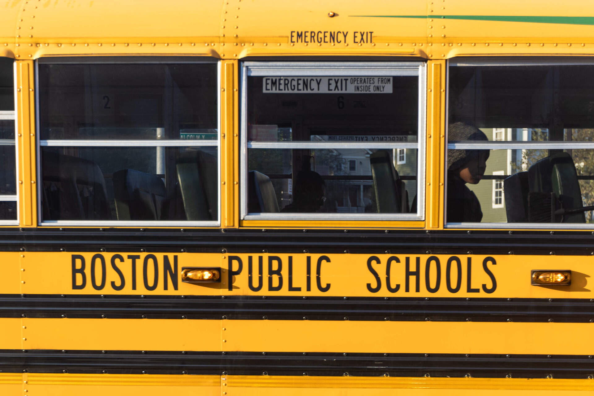 A student looks out the window of a school bus on Malcolm X Boulevard in Roxbury. (Jesse Costa/WBUR)