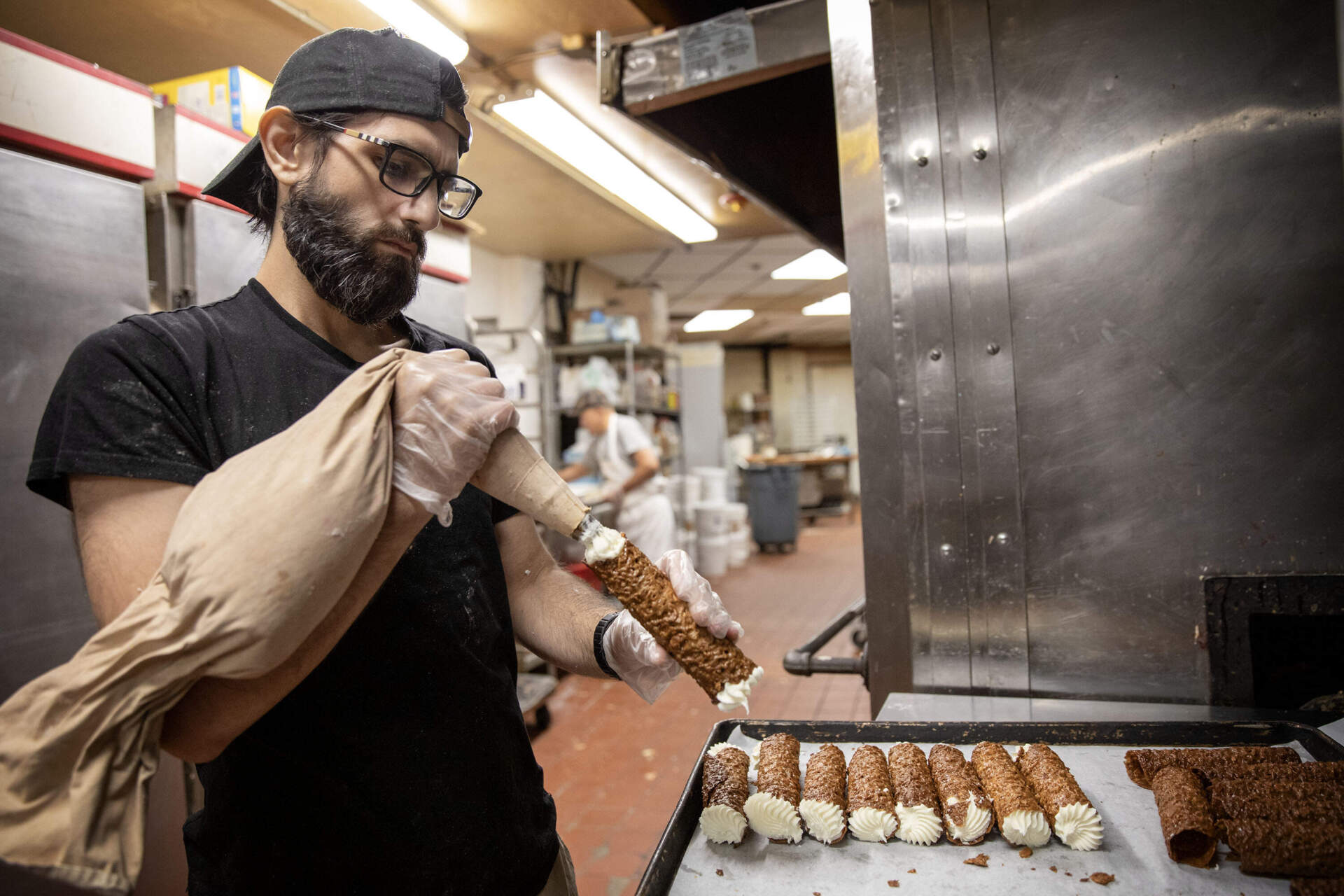 "Little" Pat Bova fills cannolis at Bova's Bakery. (Robin Lubbock/WBUR)