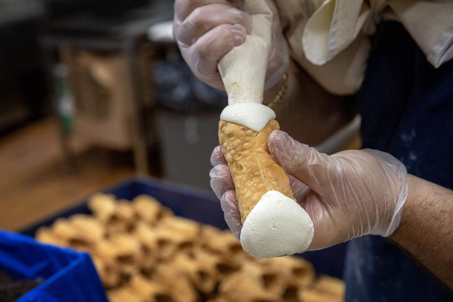 A cannoli (or cannolo if you want to be grammatically correct) gets filled in the kitchen of Mike's Pastry in Boston's North End. (Robin Lubbock/WBUR)