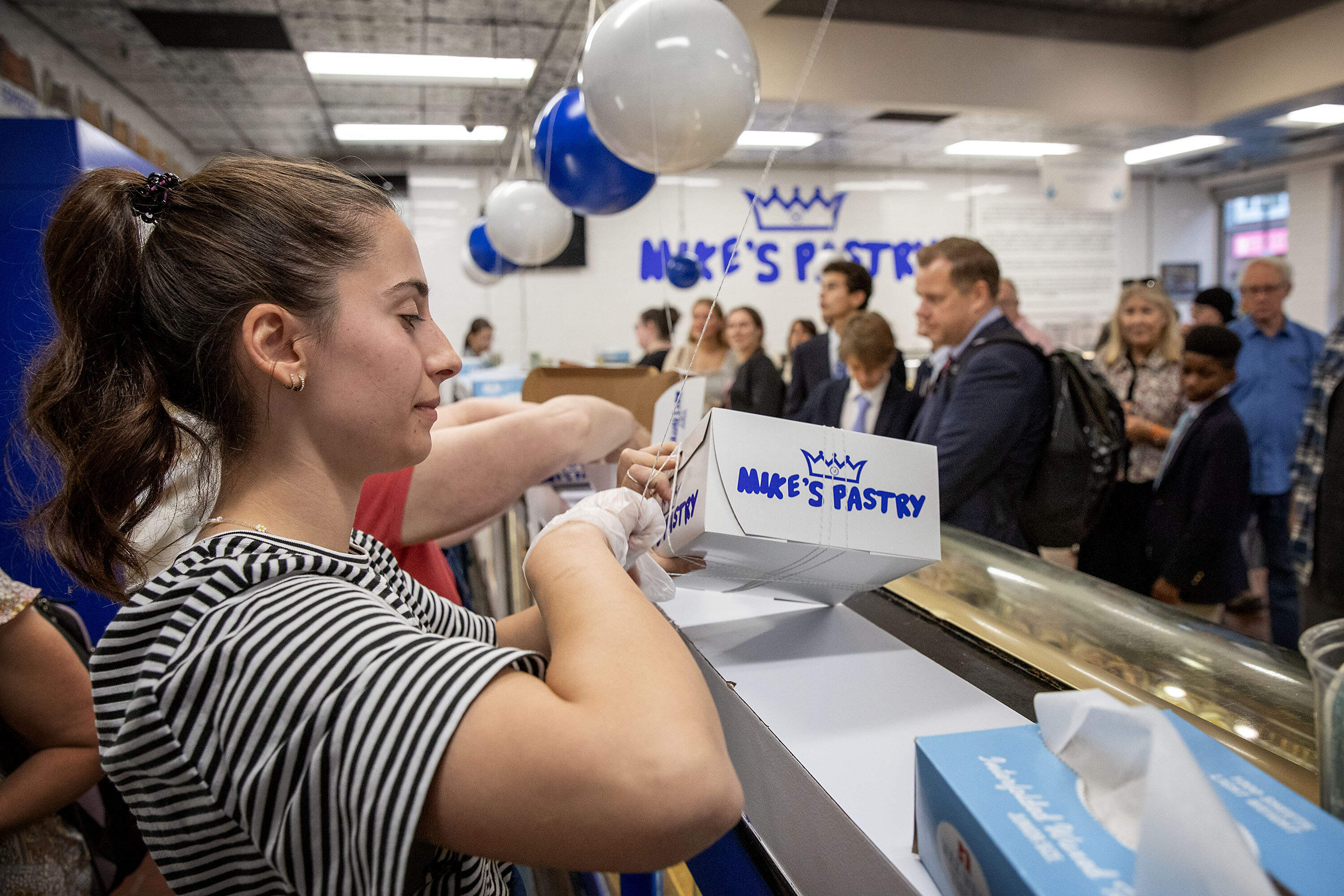 A bakery worker boxes pastries for a customer at Mike's Pastry on Hanover Street. (Robin Lubbock/WBUR)