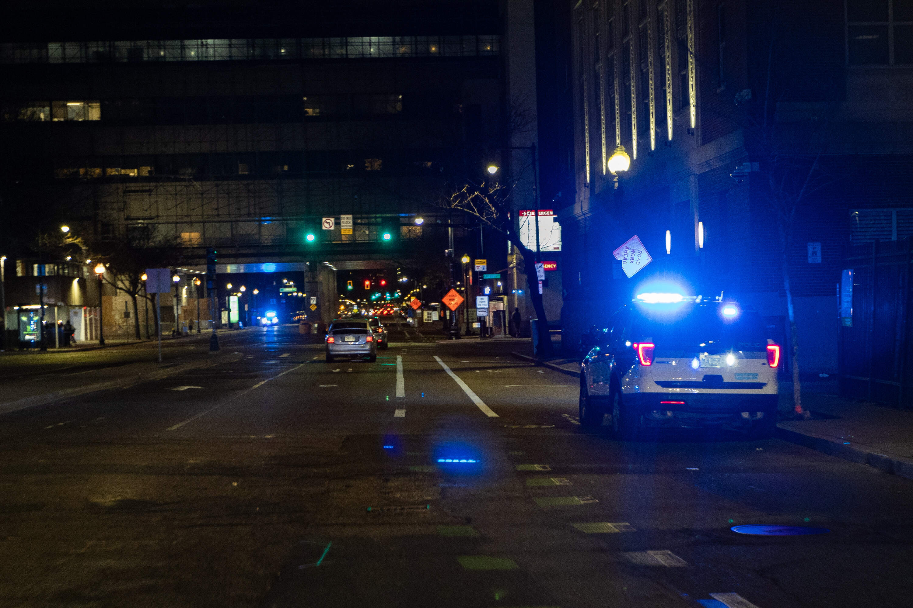 Boston Police cruisers parked on Massachusetts Avenue with their lights flashing to emphasize their presence all around the "Mass. and Cass" area. (Jesse Costa/WBUR)