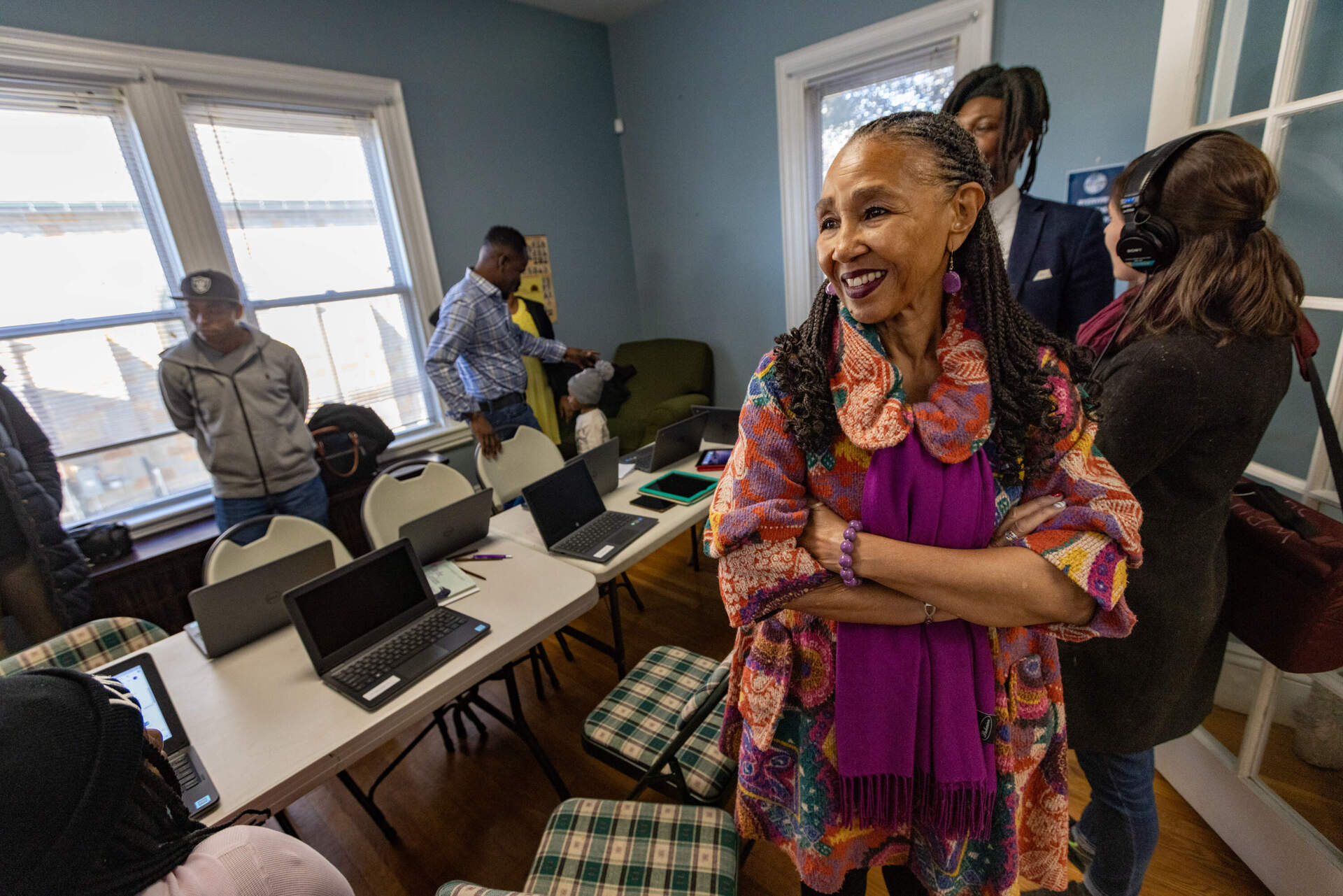 Pastor Gloria White-Hammond smiles as she watches the eight families the church has taken in congregate in the community room. (Jesse Costa/WBUR)