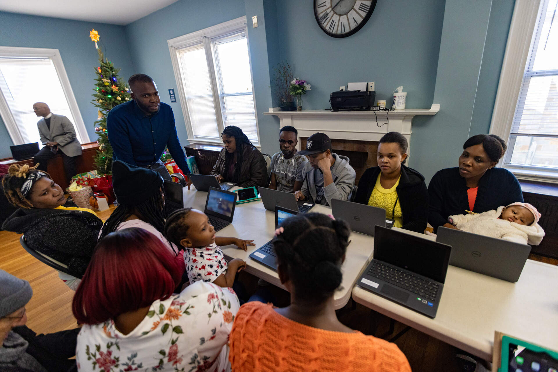 Huguens Altidor leads a computer skills class with a group migrants recently taken in by the Bethel AME Church in Jamaica Plain. (Jesse Costa/WBUR)
