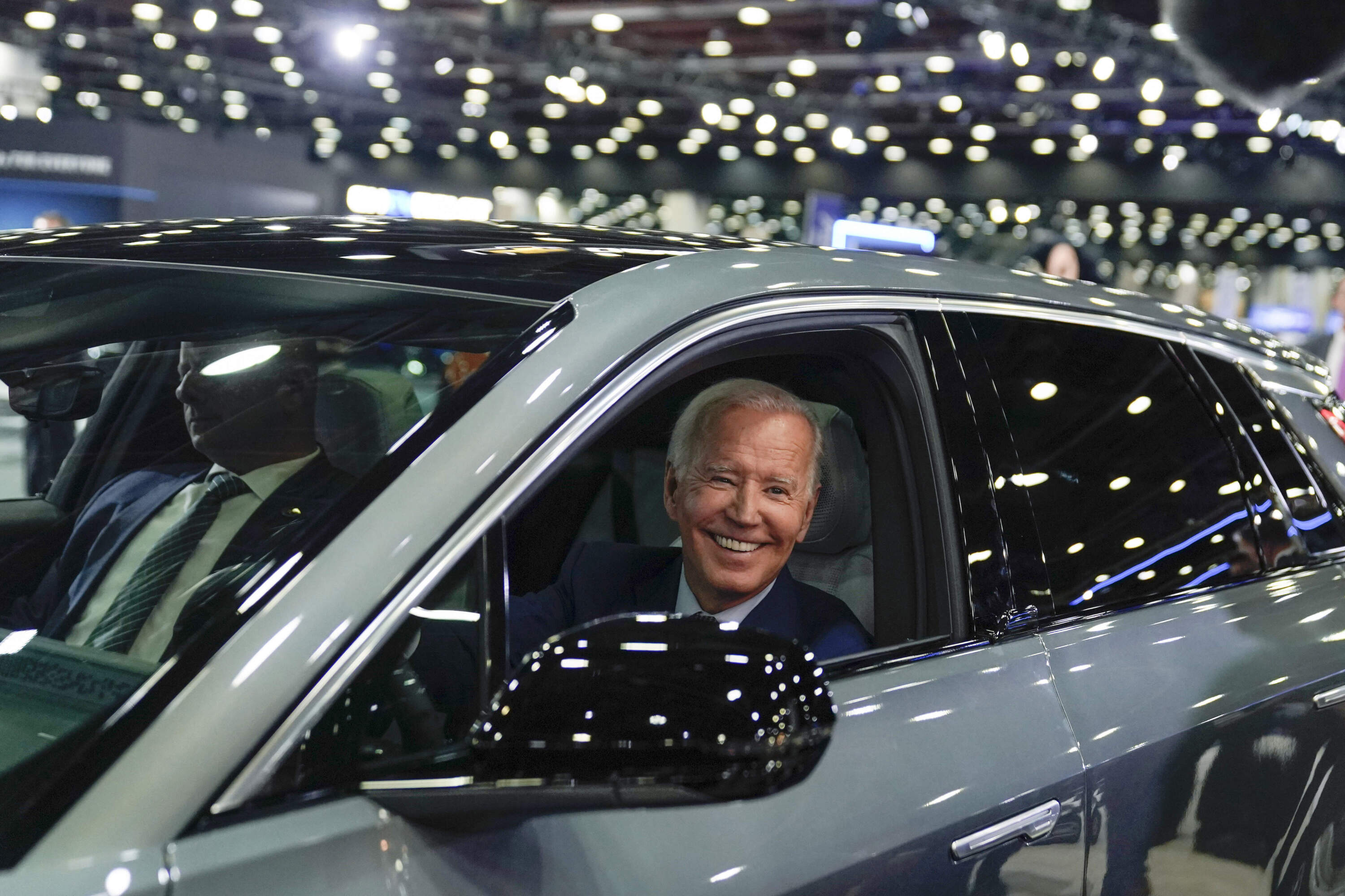 President Joe Biden drives a Cadillac Lyriq through the showroom during a tour at the Detroit Auto Show, Sept. 14, 2022, in Detroit. (AP Photo/Evan Vucci, File)