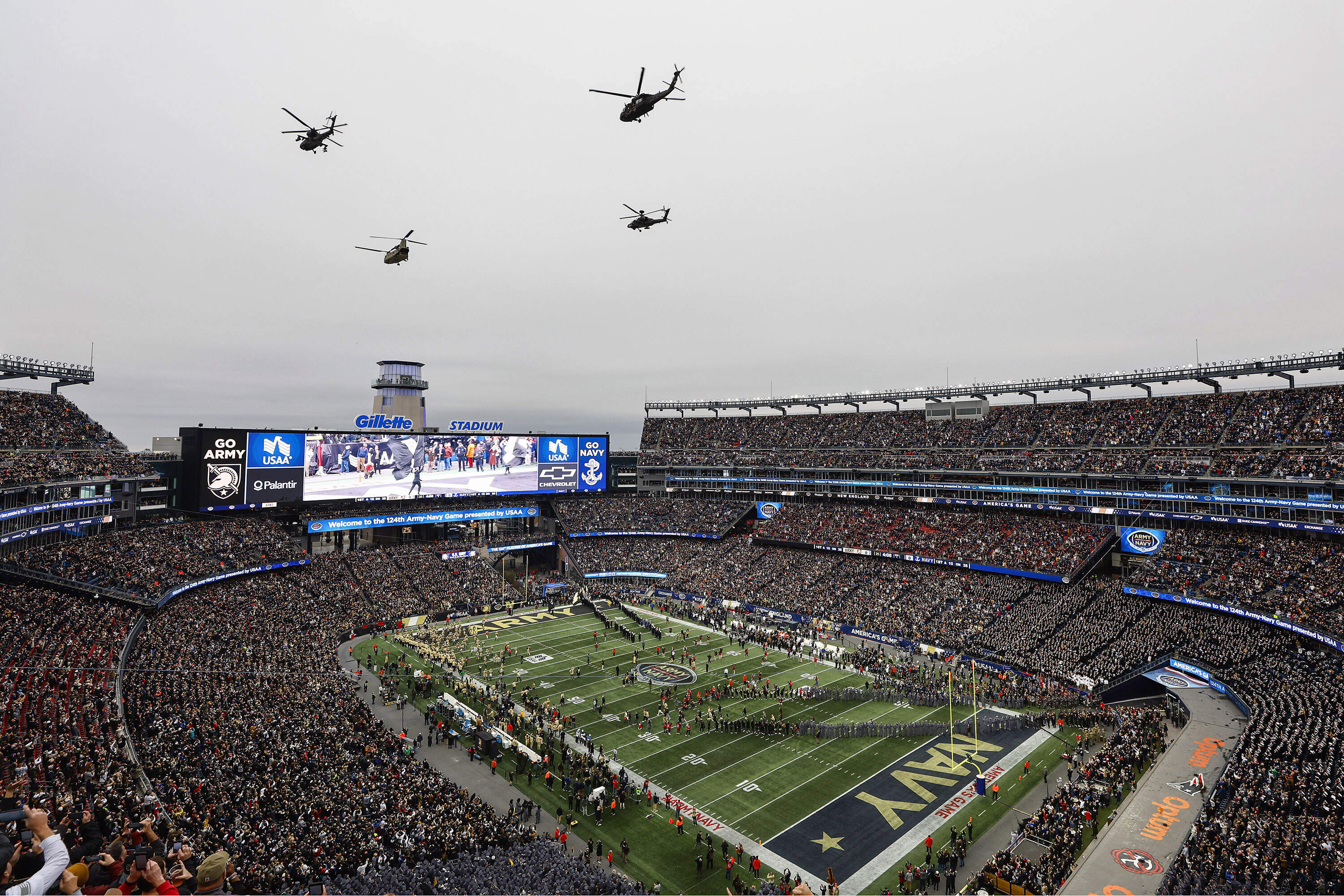 Helicopters fly over Gillette Stadium before an NCAA football game between the Navy and the Army. (Winslow Townson/AP)