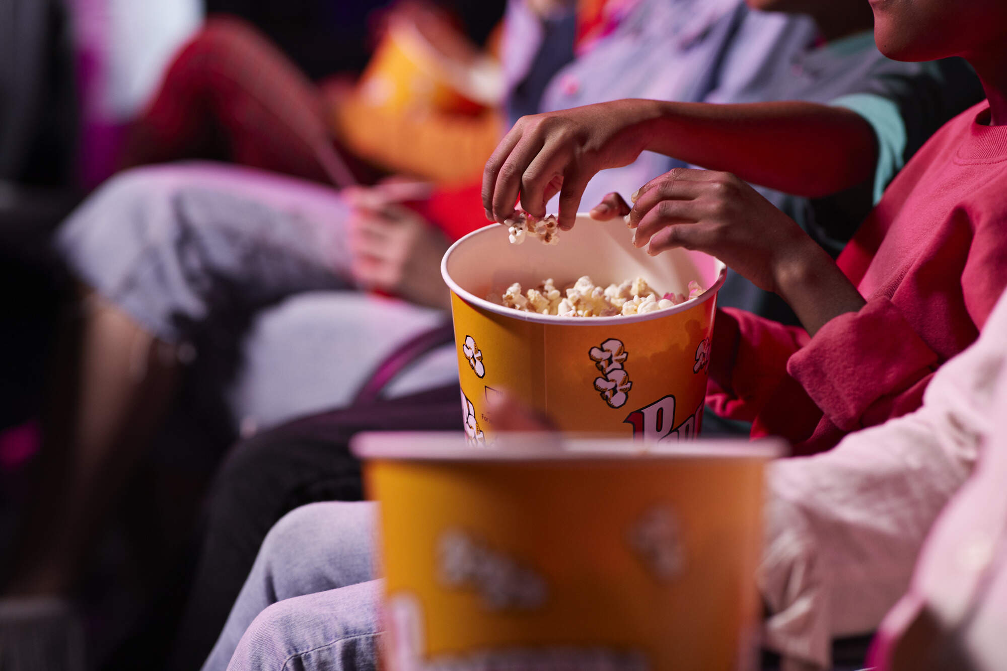 Moviegoers eat popcorn. (Klaus Vedfelt/Getty Images)
