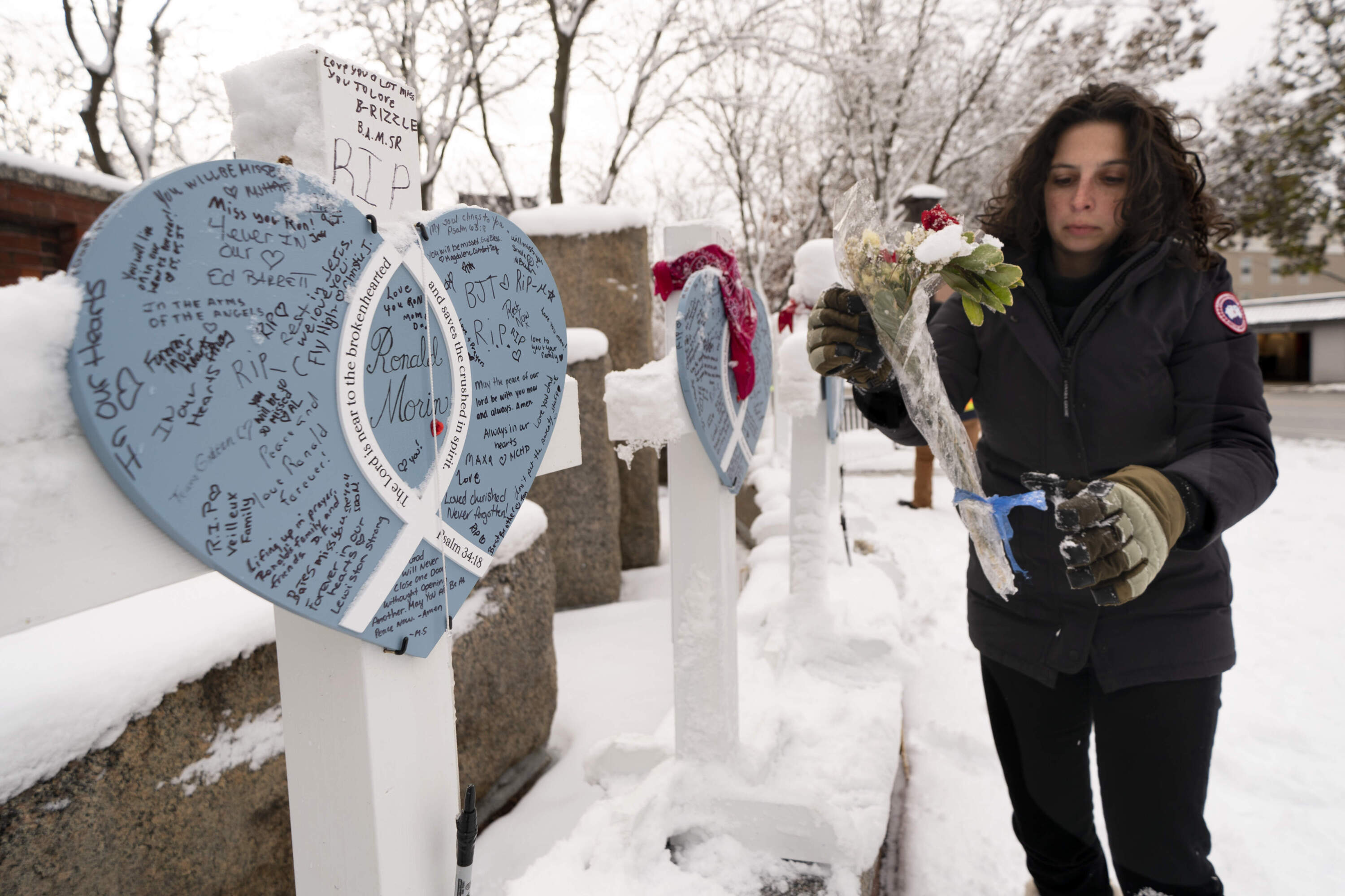 Rachel Ferrante, executive director of the Maine MILL, gathers items from a makeshift memorial for the victims of last month's mass shooting. (Robert F. Bukaty/AP)
