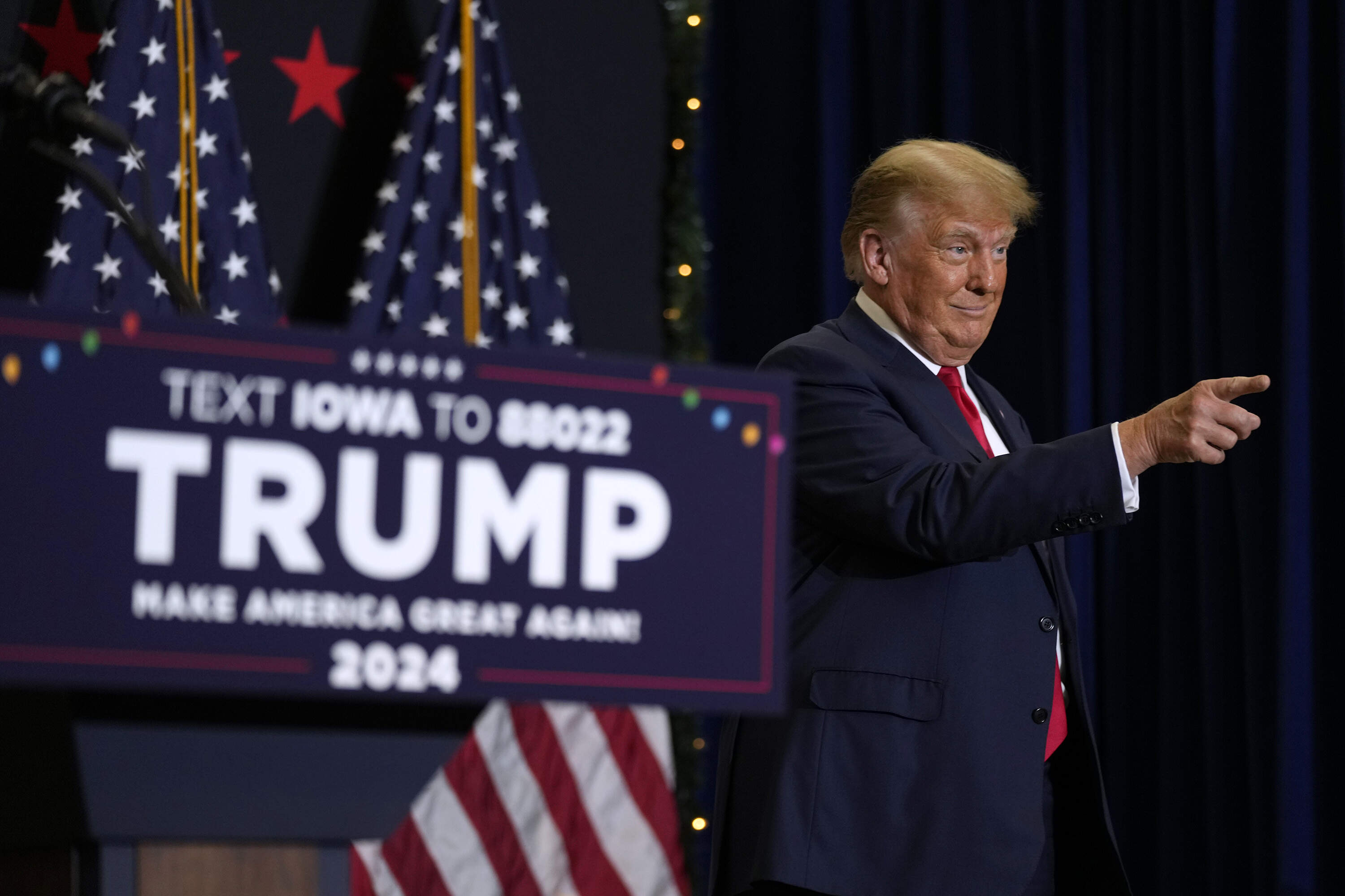 Former President Donald Trump greets supporters as he arrives at a rally on Dec. 19, 2023, in Waterloo, Iowa. (Charlie Neibergall/AP)