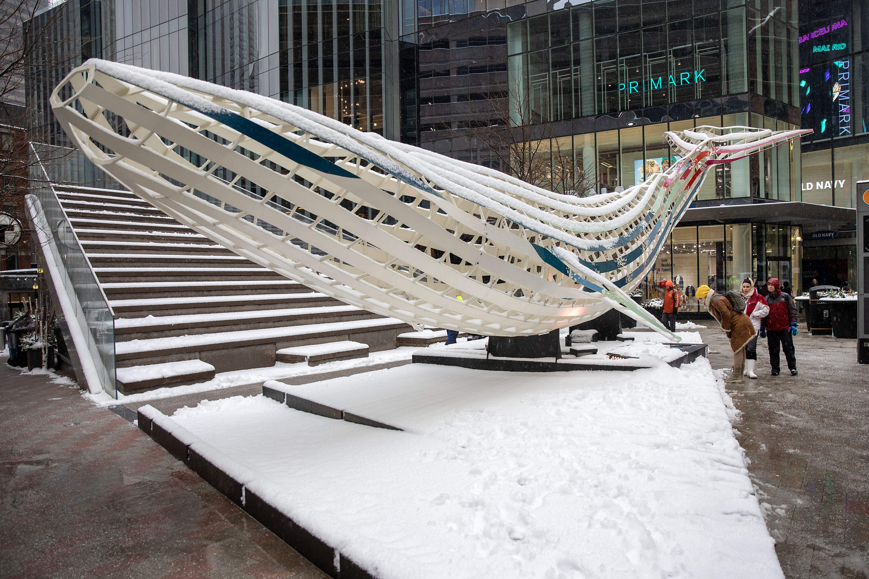 Pedestrians on Washington Street stop to look at "Echoes--A Voice from Uncharted Waters", one of the Winteractive art works on display in downtown Boston. (Robin Lubbock/WBUR)