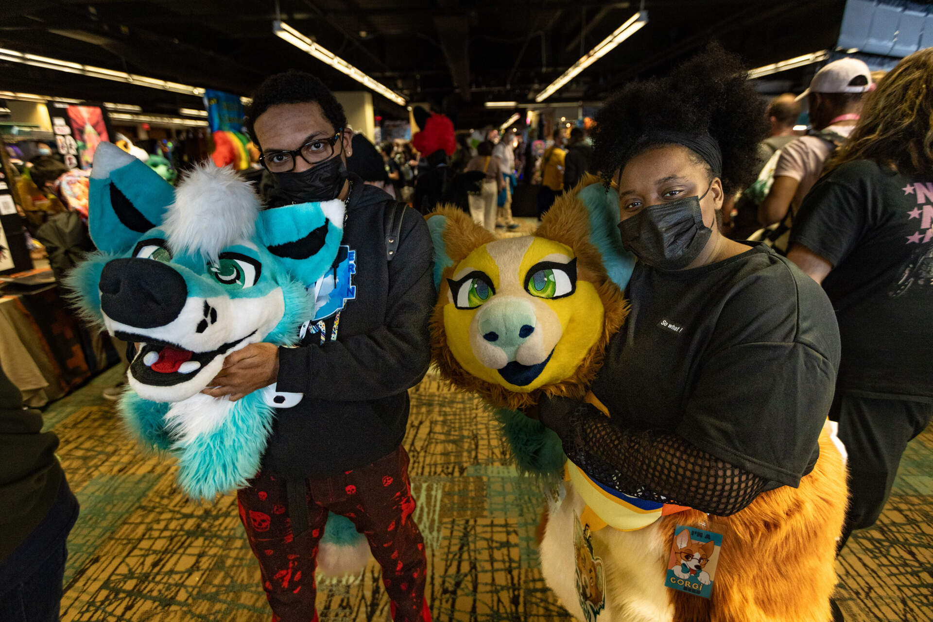 Khalil Reid, a.k.a. Erin, a Brooklyn fox and Moon, a corgi from New Jersey, pose without their costume heads in Vendor Hall at the Anthro New England conference. (Jesse Costa/WBUR)