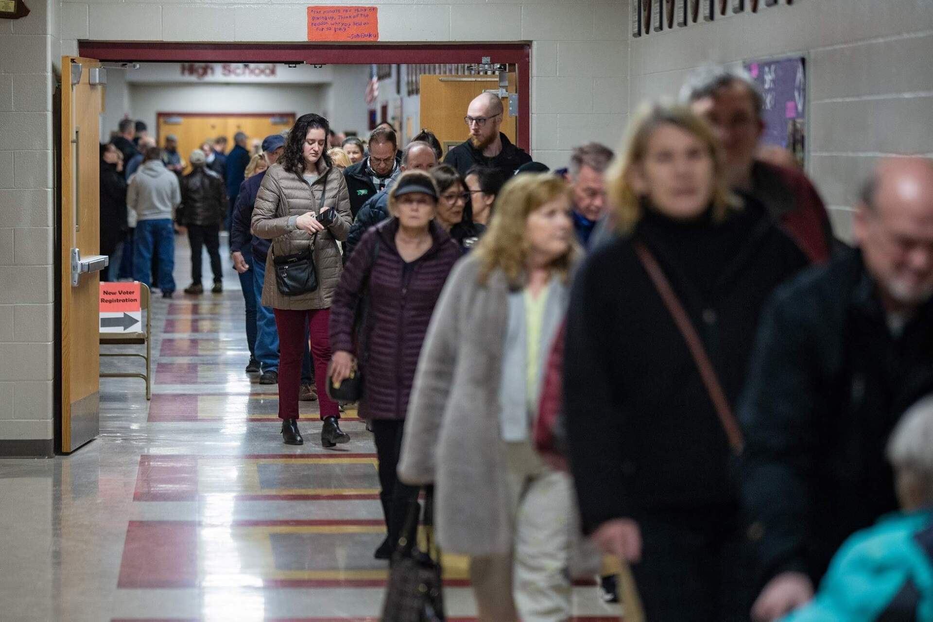New Hampshire voters line up in a hallway of Bedford High School as the polls open in the morning on Tuesday. (Jesse Costa/WBUR)